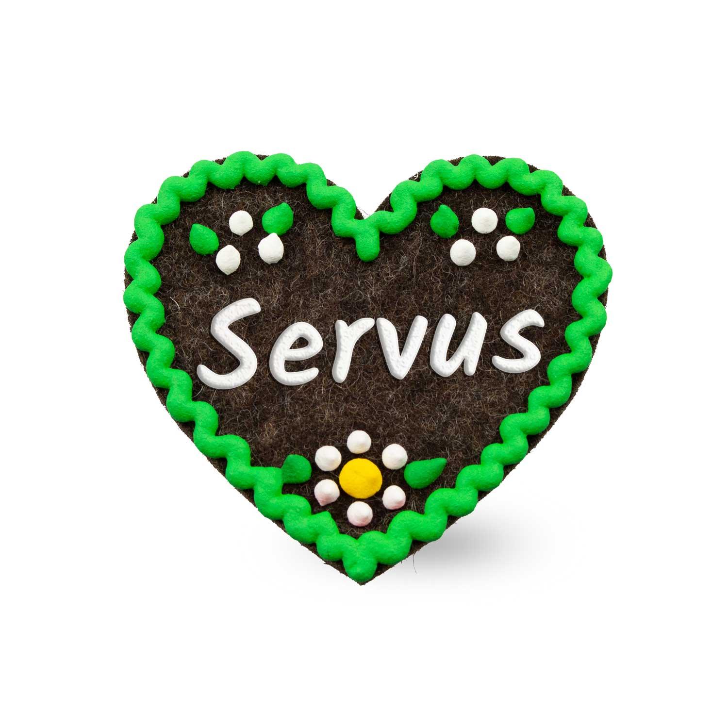 Herzförmiger Filzanstecker mit gesticktem Schriftzug „Servus“ und Ziernaht; ca. 6,5 x 7 cm, mit Sicherheitsverschluss.