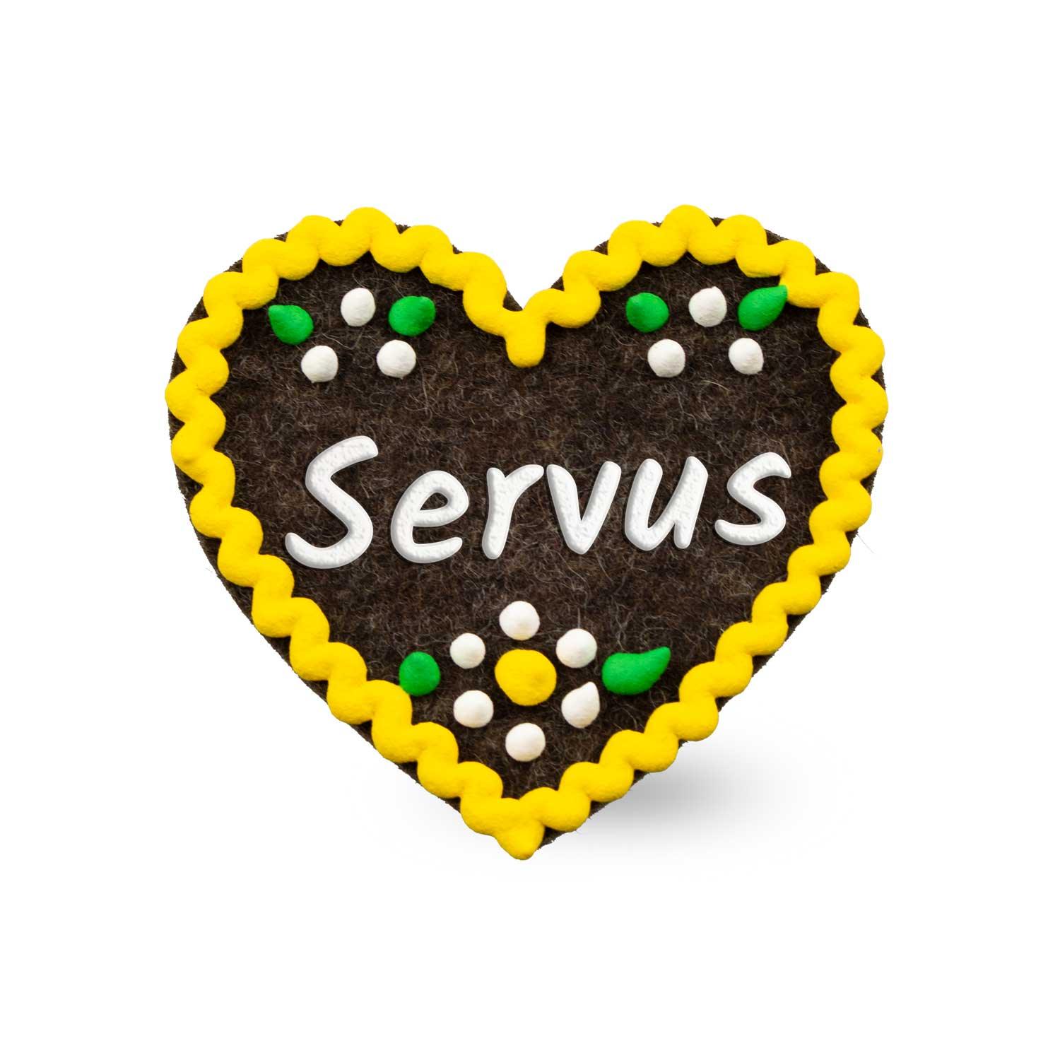 Herzförmiger Filz-Anstecker mit gesticktem „Servus“-Schriftzug und rückseitigem Sicherheitsverschluss, ca. 6,5 × 7 cm.