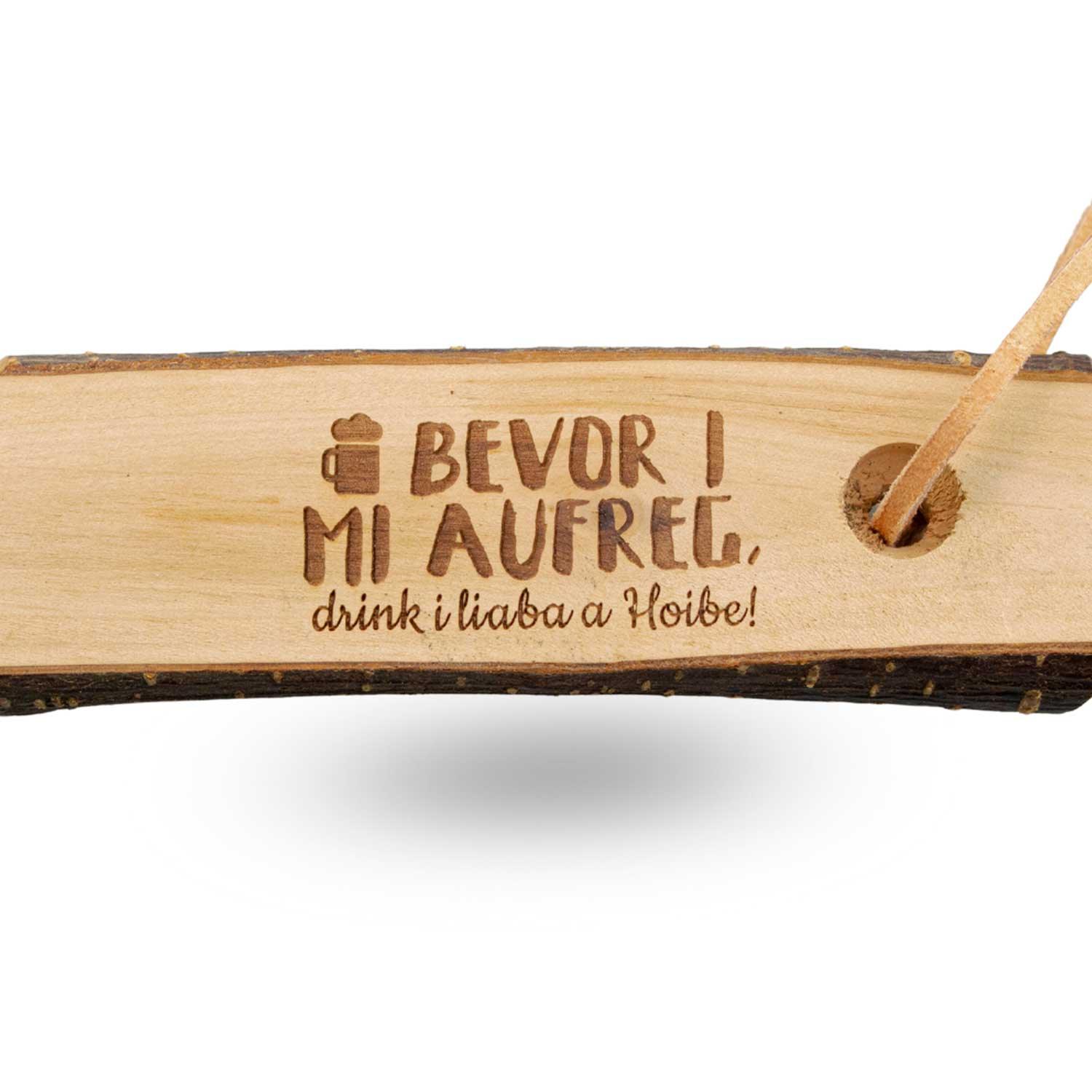 Flaschenöffner aus Holz mit metallischer Kapselheber-Spitze und Gravur „Bevor i mi aufreg, drink i liaba a Hoibe“, ca. 16 cm.