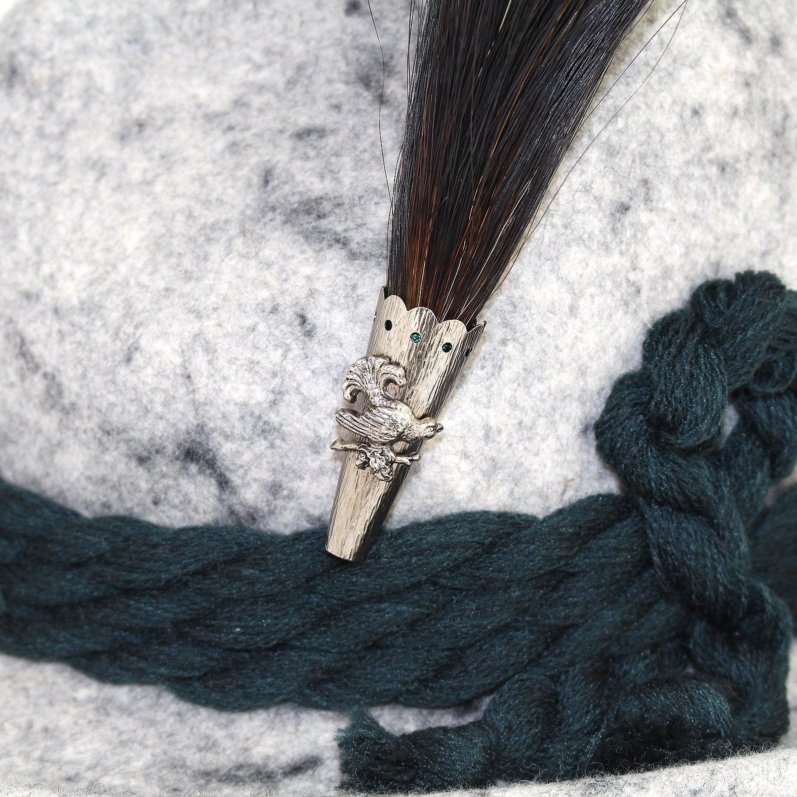 Originaler Gamsbart mit dunklem Naturhaar, silberfarbener Barthülse und Auerhahn-Applikation, ca. 15 cm hoch.