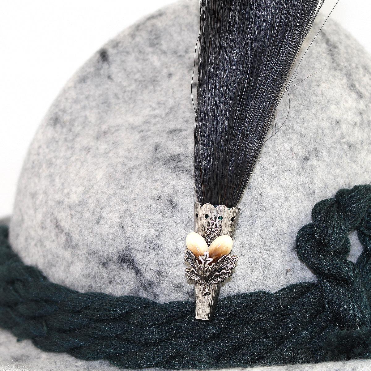 Original bayerischer Gamsbart aus dunkelbraunem Antilopenhaar mit Hirschzahnimitation, ca. 16 cm hoch.