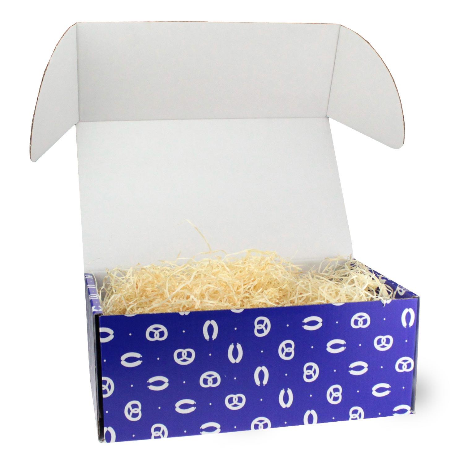 Osterhas Geschenkbox mit blauem Design und weißen Brezeln, befüllt mit heller Holzwolle als Füllmaterial.