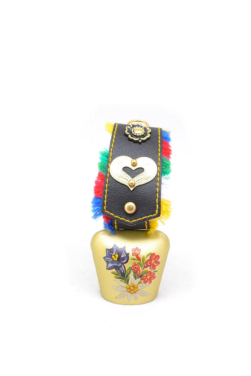 Handbemalte Kuhglocke mit buntem Fransenband, Edelweißmotiv und traditionellem bayerischem Muster aus Metall.