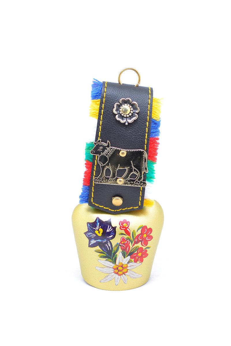 Handbemalte Kuhglocke mit Edelweißmotiv, verziertem Fransenband und traditionellem bayerischem Design.