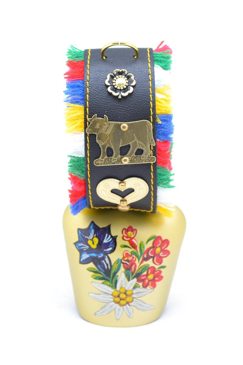 Handbemalte Kuhglocke mit floralem Edelweiß-Motiv, Messingoptik, Fransenband in Rot mit Stickerei.