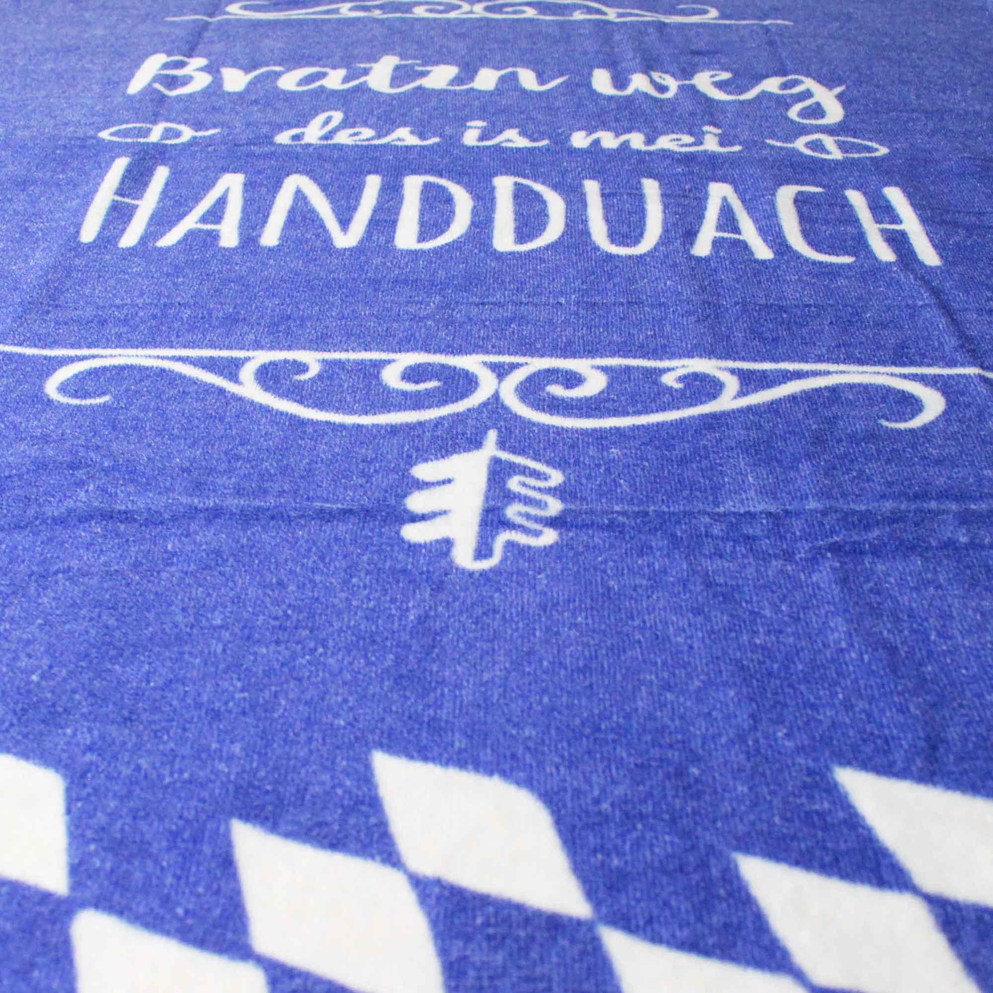 Graues Handtuch mit weißem Schriftzug „Bratzn weg“ und bayerischem Löwenmotiv, weich, 100 % Baumwolle, 80 × 155 cm.