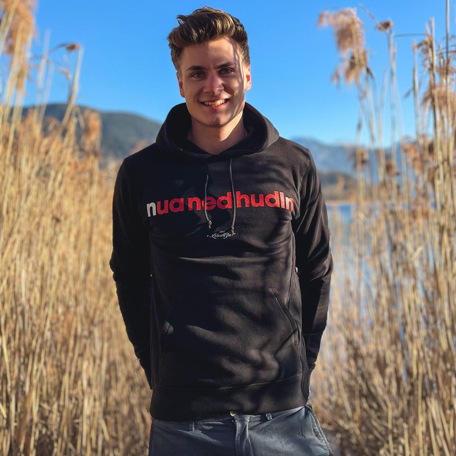 Grauer Herren-Hoodie mit Kapuze, Frontprint „Nua ned hudln“ in Weiß, aus Bio-Baumwolle und recyceltem Polyester.