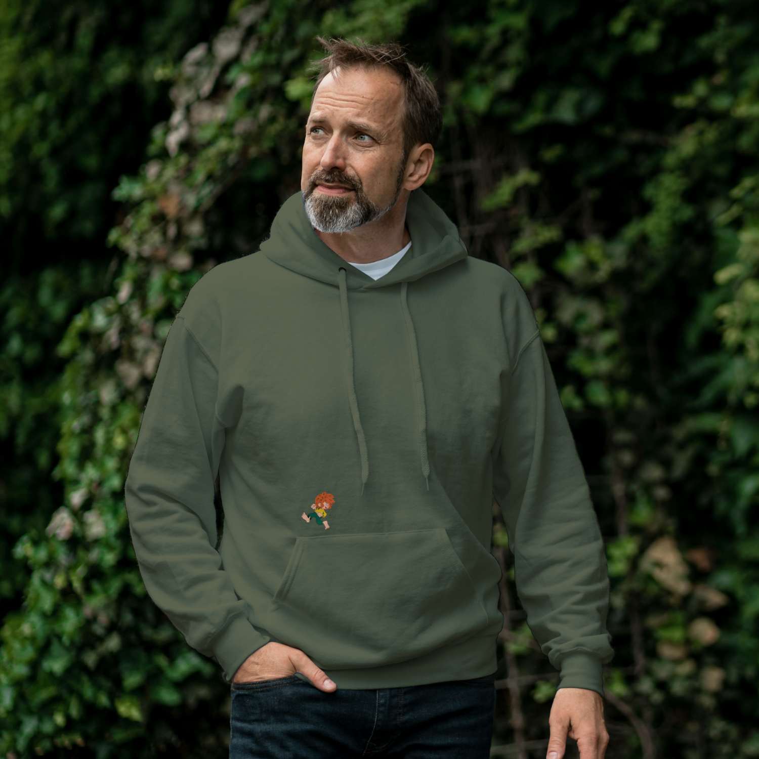 Mann trägt grünen Pumuckl Lausbua Unisex Hoodie mit kleinem Pumuckl Stick auf der Brust, ideal für Fans.