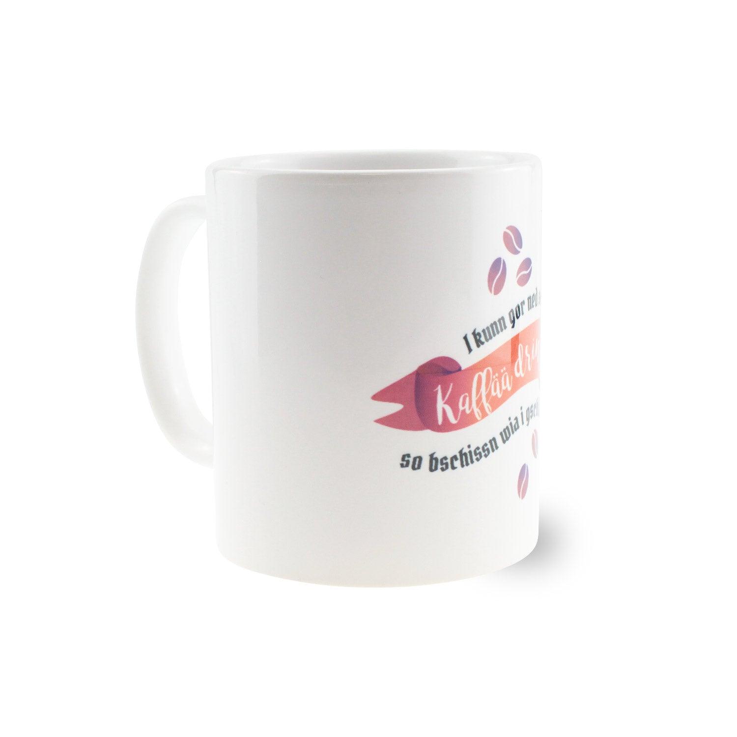 Weiße Tasse mit schwarzem Henkel und Aufdruck „I kunn gor ned so vui Kaffää dringa…“, rund, ca. 330 ml, Keramik.