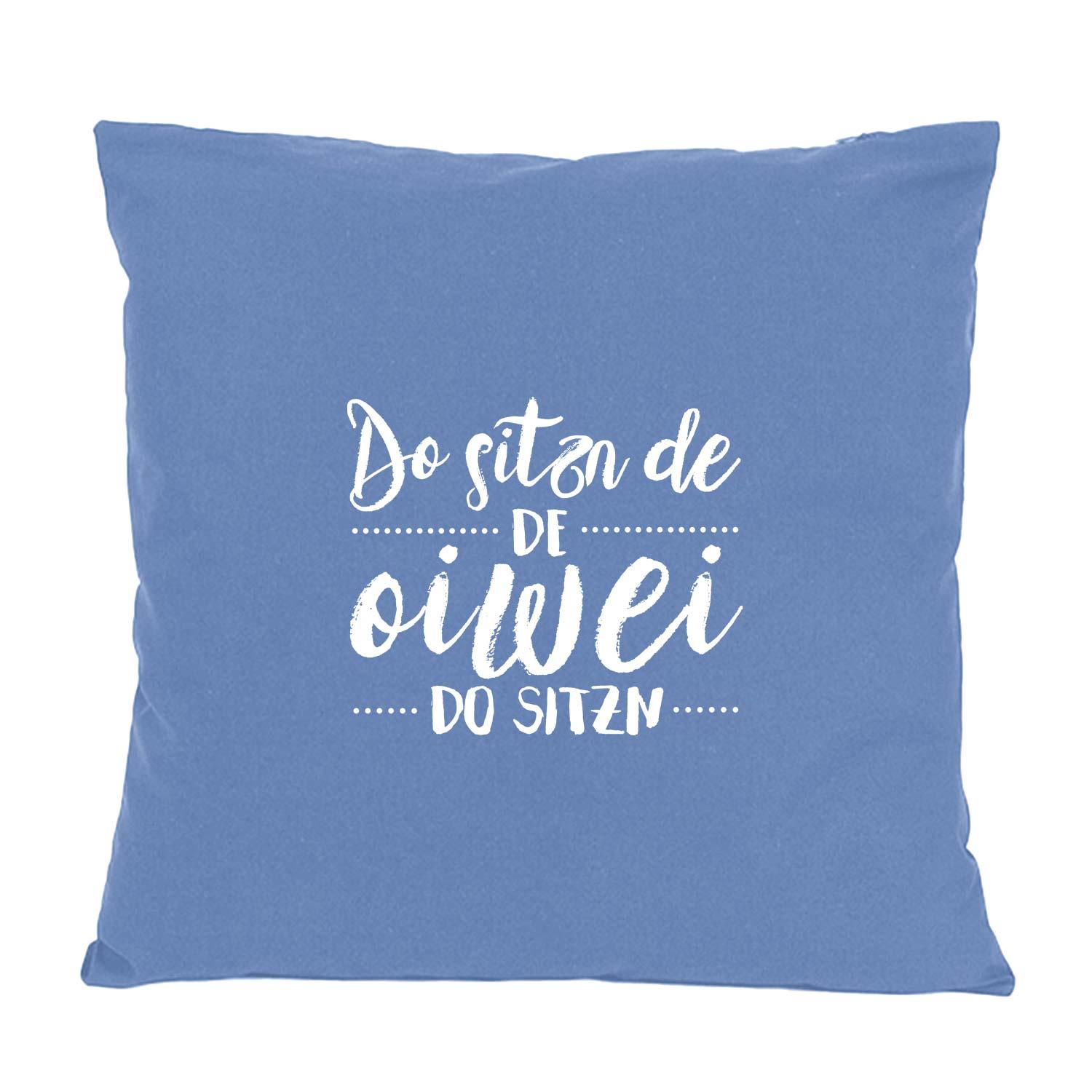 Quadratisches Dekokissen mit auffälligem Schriftzug „Do sitzn de...“ in Druckschrift, Baumwolle, ca. 40 x 40 cm.