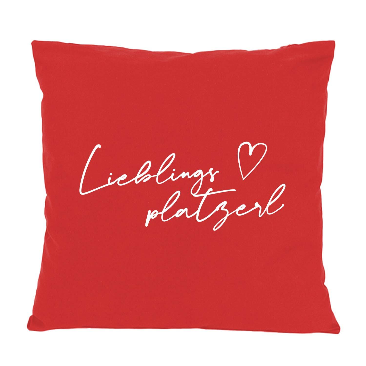 Quadratisches Dekokissen mit auffälligem „Lieblingsplatzerl“-Schriftzug, bedruckt in Bayern, aus 100 % Baumwolle, ca. 40 x 40 cm.