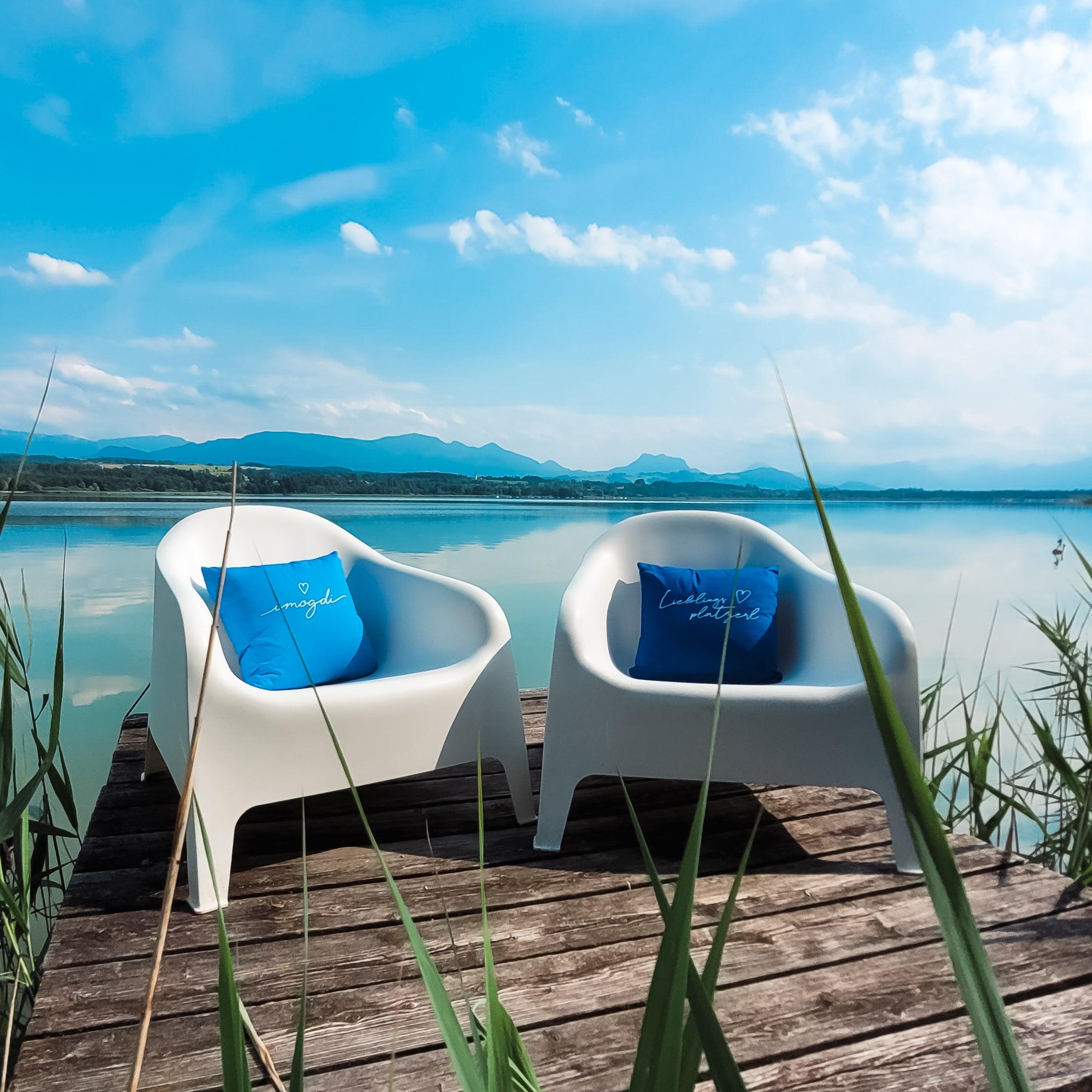 Quadratisches Dekokissen mit sichtbarem Schriftzug „Lieblingsplatzerl“ auf strukturierter Oberfläche; 100 % Baumwolle, ca. 40 × 40 cm.