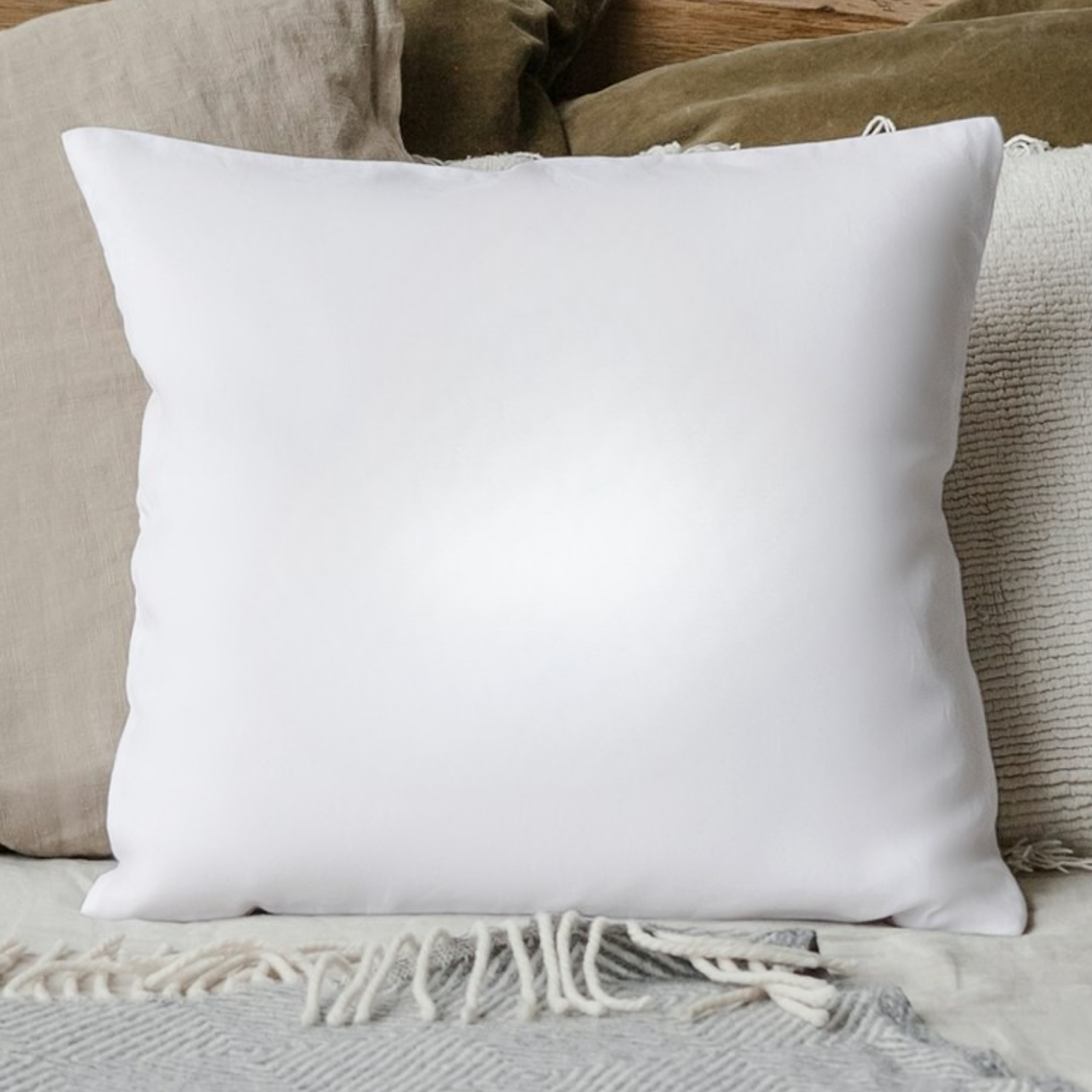 Weißes, quadratisches Kissen auf Bett mit dekorativem Bezug und Decke, ideal für personalisierten Druck.