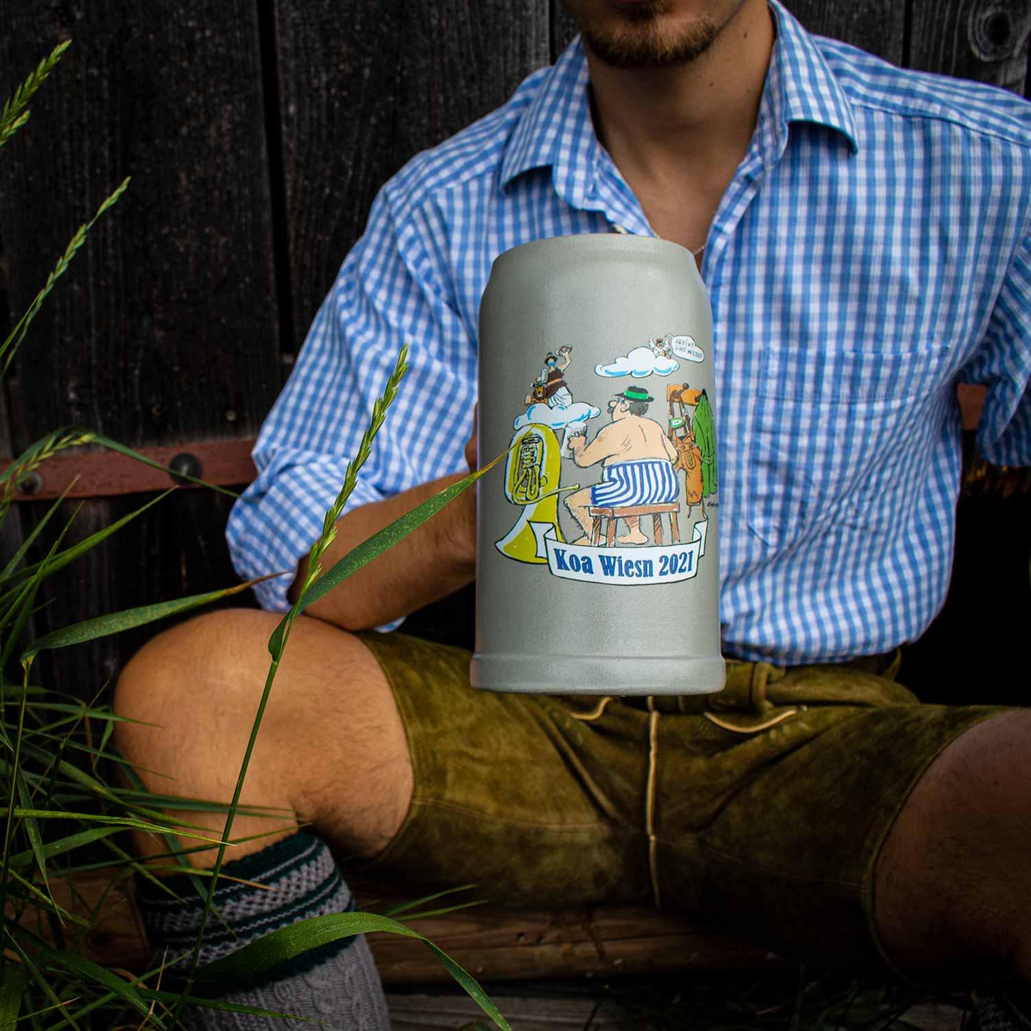 Limitierter, bauchiger Bierkrug aus Keramik mit buntem Wiesn-Motiv und Schriftzug „Koa Wiesn 2021“, 1,0 Liter.