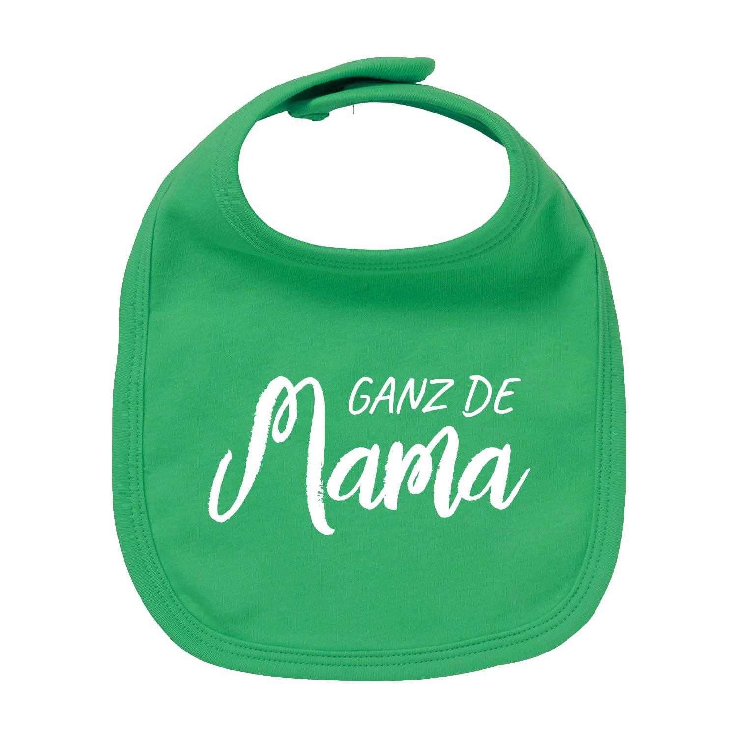 Weißes Baby-Lätzchen mit rotem Herz-Aufdruck und rotem Schriftzug „Ganz de Mama“, aus Bio-Baumwolle gefertigt.