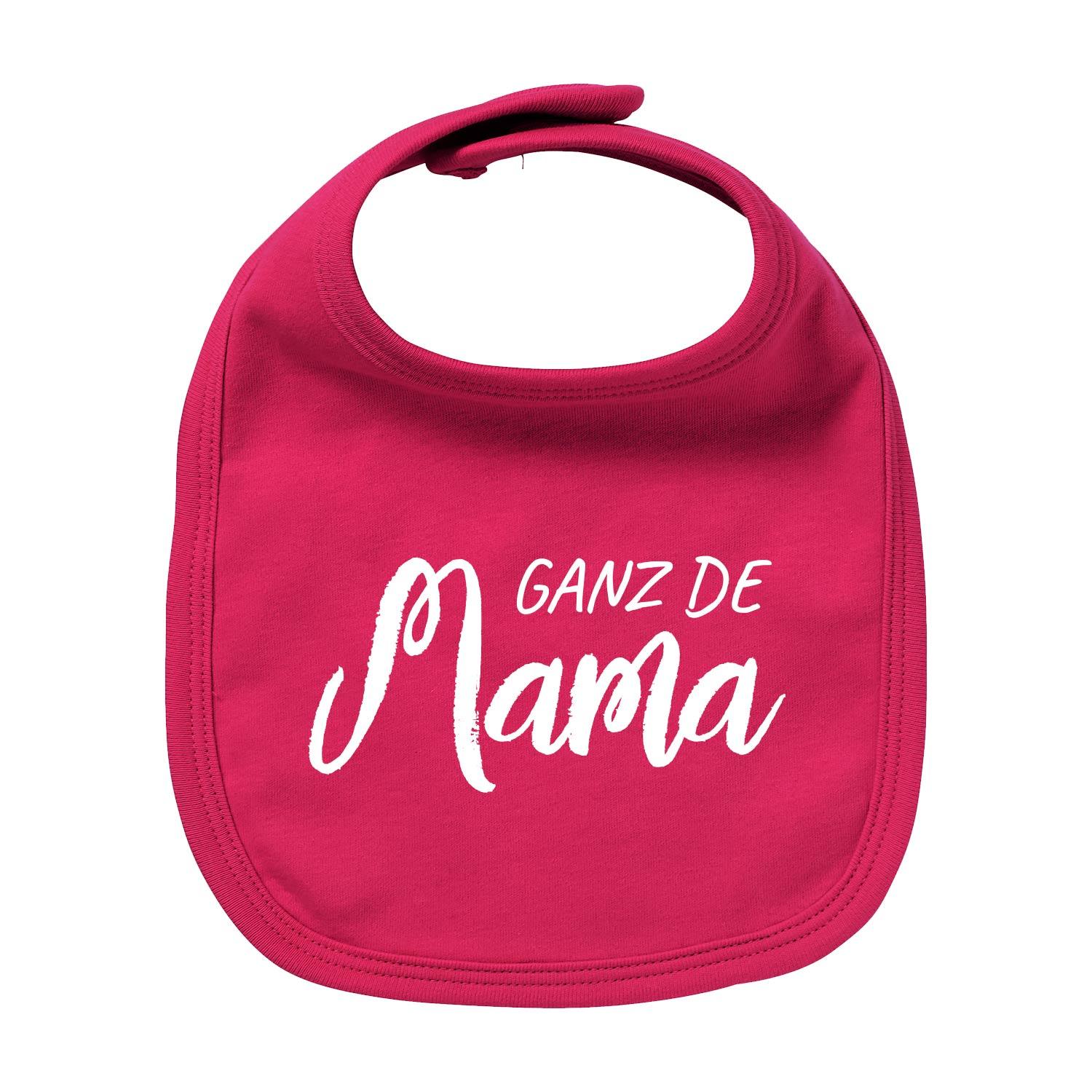 Weißes Baby-Lätzchen mit rotem Herz-Motiv, roter Schrift „Ganz de Mama“, runder Halsausschnitt, Bio-Baumwolle.