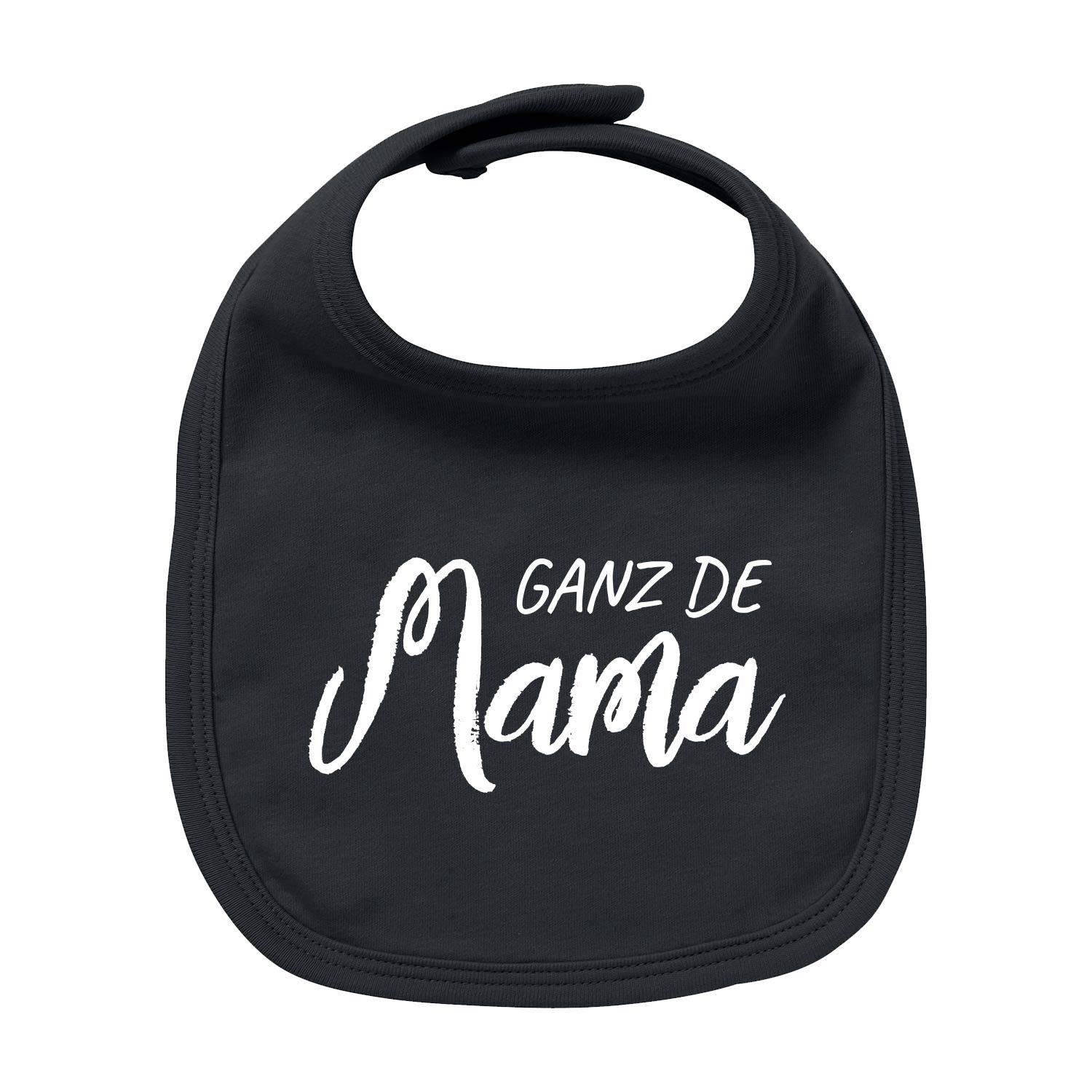 Weißes Baby-Lätzchen aus Bio-Baumwolle mit rotem Herzmotiv und rotem Schriftzug „Ganz de Mama“, rechteckige Form.