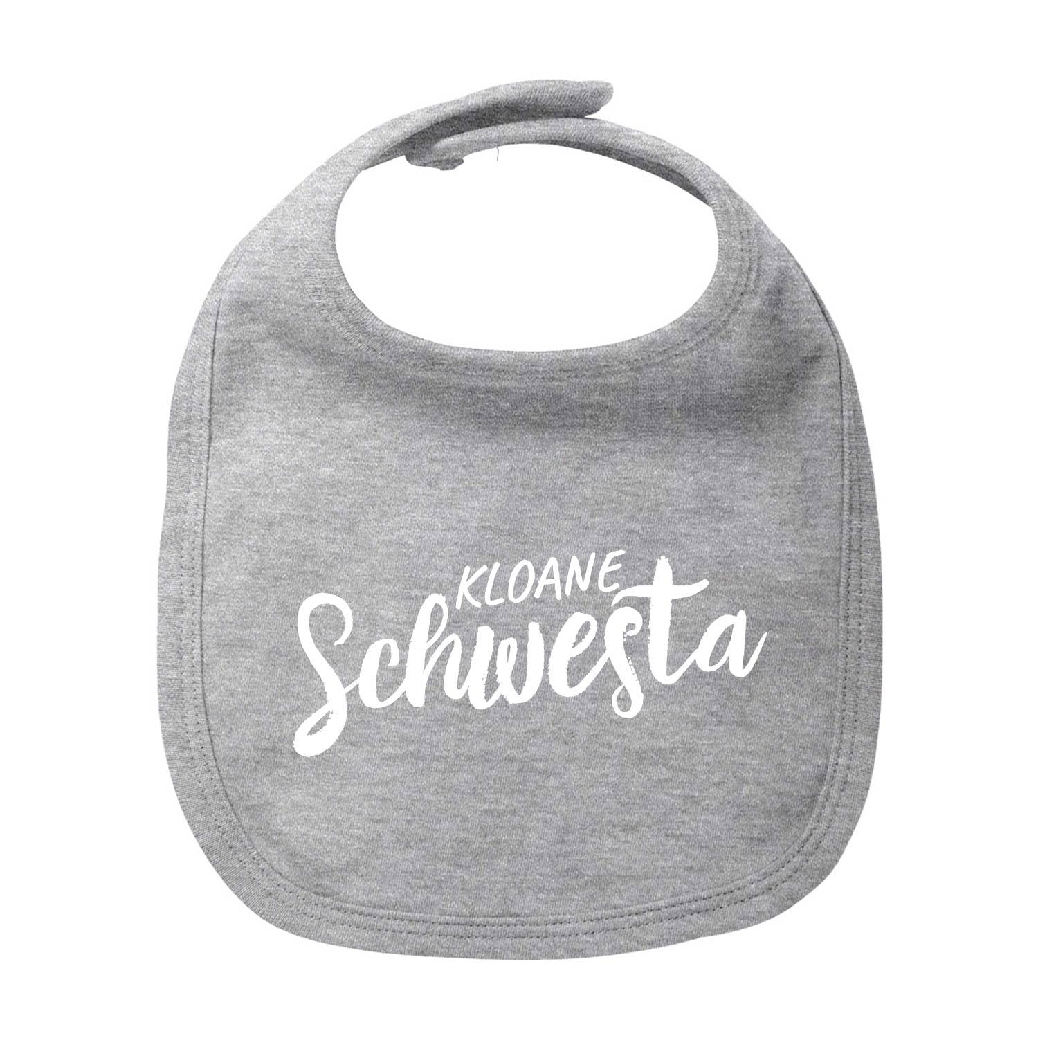 Weißes Baby-Lätzchen mit rosa Schriftzug „Kloane Schwesta“, rundem Halsausschnitt und Bindeband, aus Bio-Baumwolle.