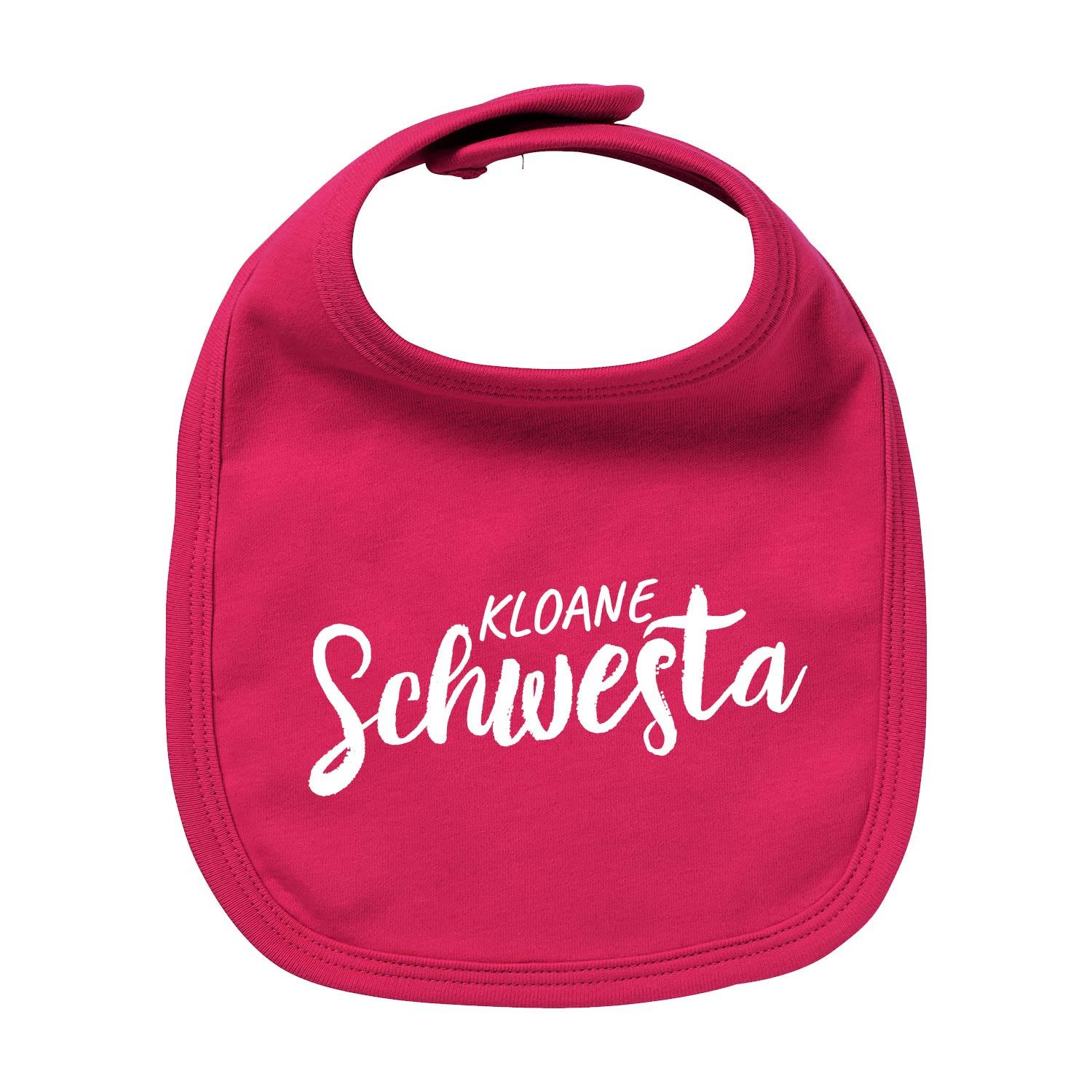 Rosa Baby-Lätzchen mit weißem Schriftzug „kloane Schwesta“, rundem Halsausschnitt und aus Bio-Baumwolle.