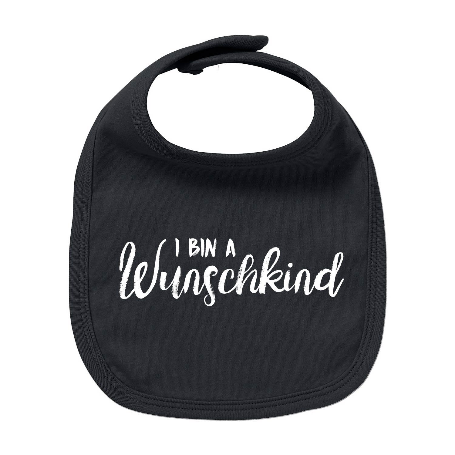 Weißes Baby-Lätzchen aus Bio-Baumwolle mit dunkelblauem Herzmotiv und rotem Schriftzug „Wunschkind“, rechteckige Form.