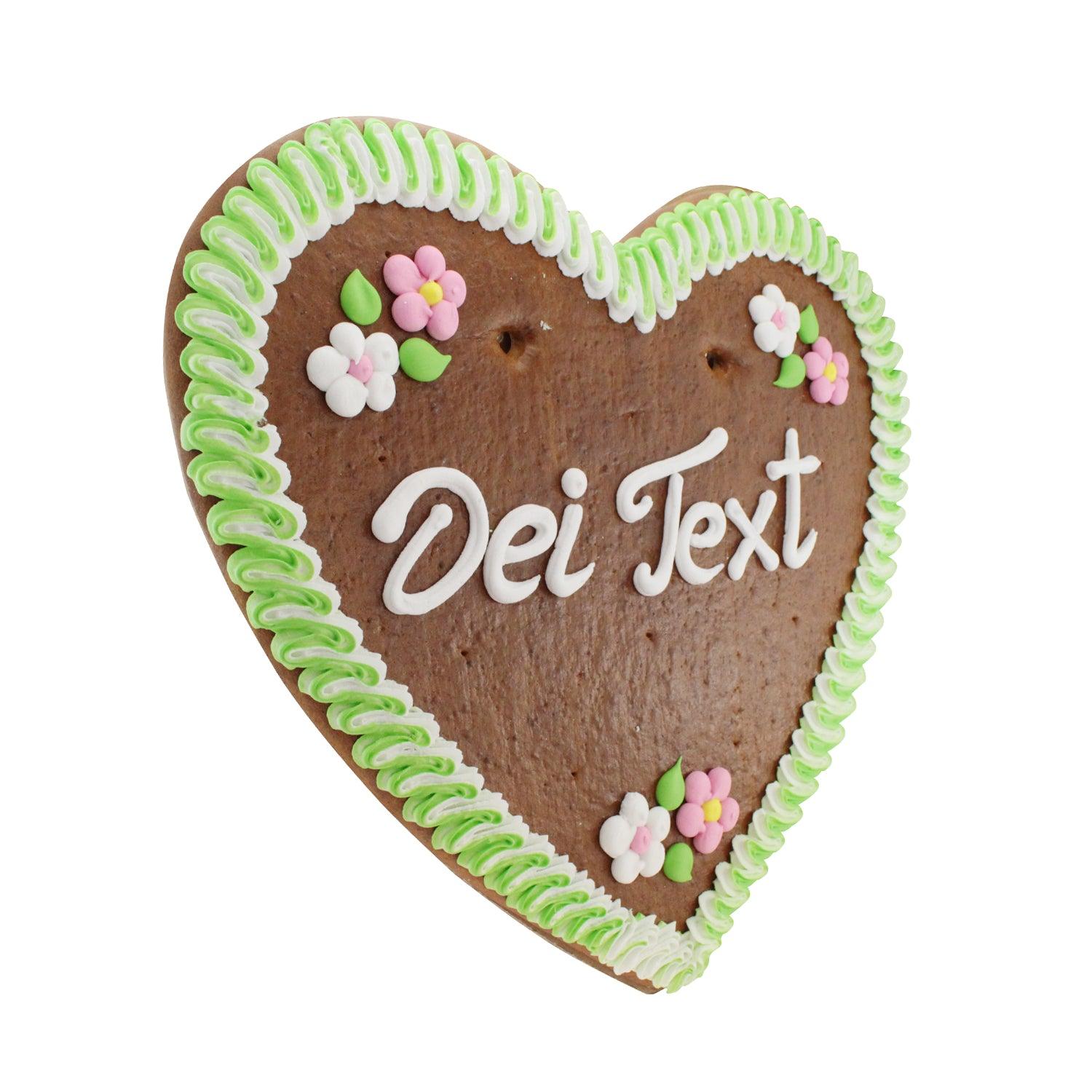 Großes, herzförmiges Lebkuchenherz mit buntem Zuckergussrand, individuell beschriftet, in Braun, Weiß, Rot und Blau.