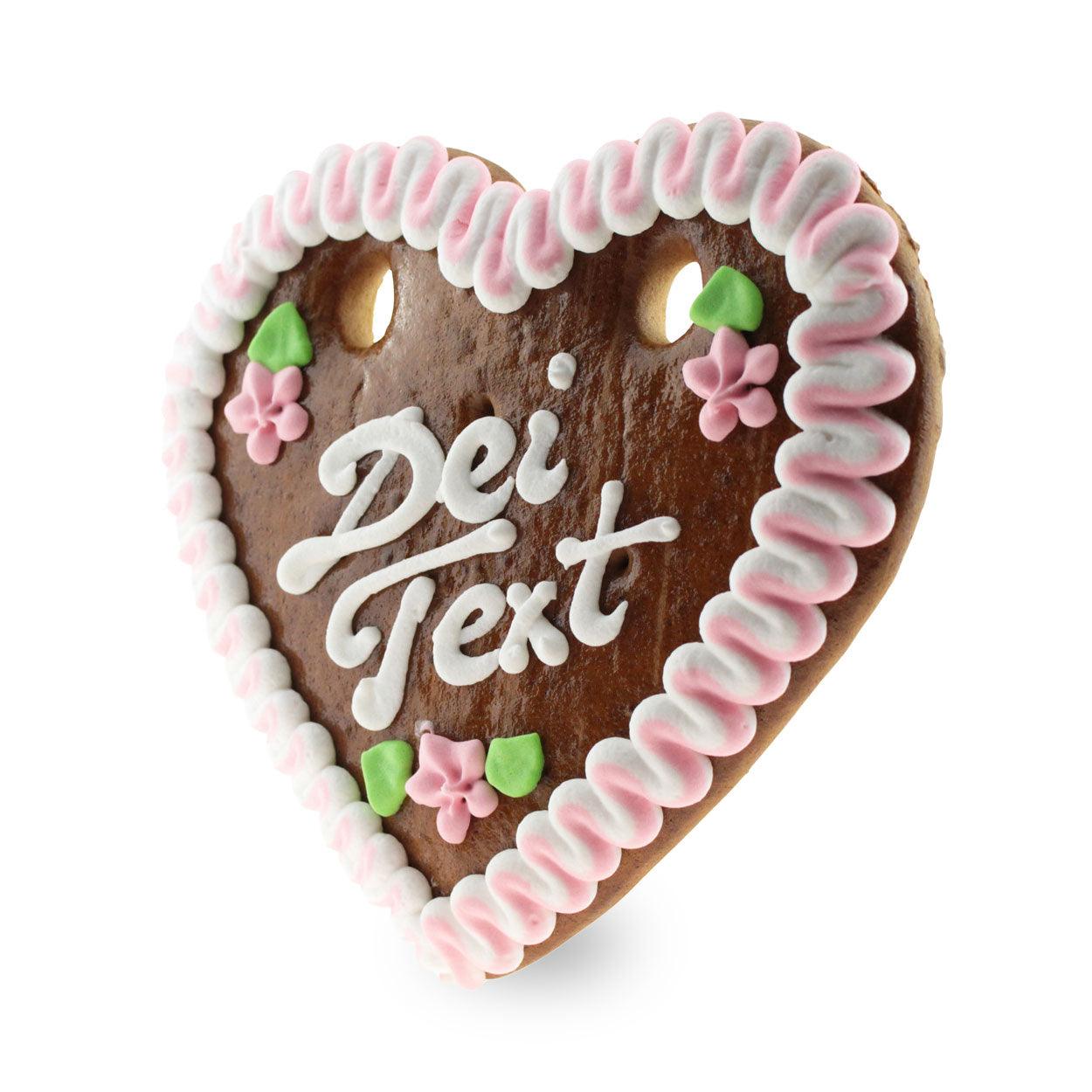 Braunes Lebkuchenherz mit weiß-rotem Rand, handbeschriftet mit individuellem Text, mit Zuckerdekor, ca. 14 × 17 cm.