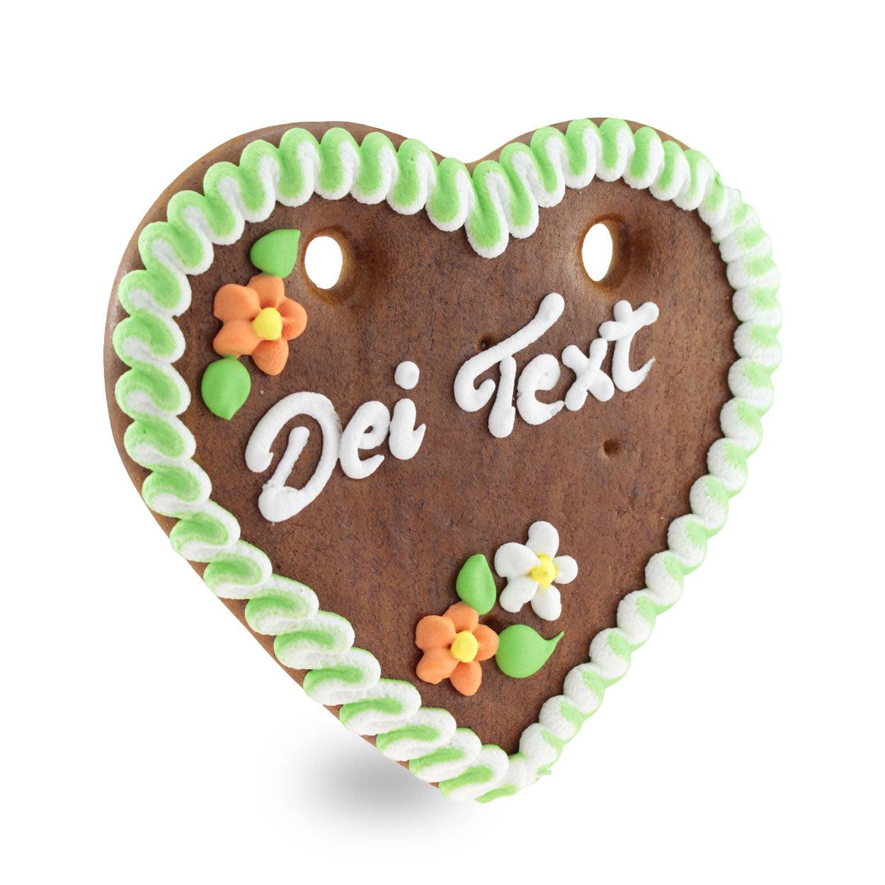 Braunes Lebkuchenherz mit weißer und blauer Zuckerdekoration, individuellem Schriftzug und rosa Zuckerröschen, ca. 14 x 17 cm, 100 g.