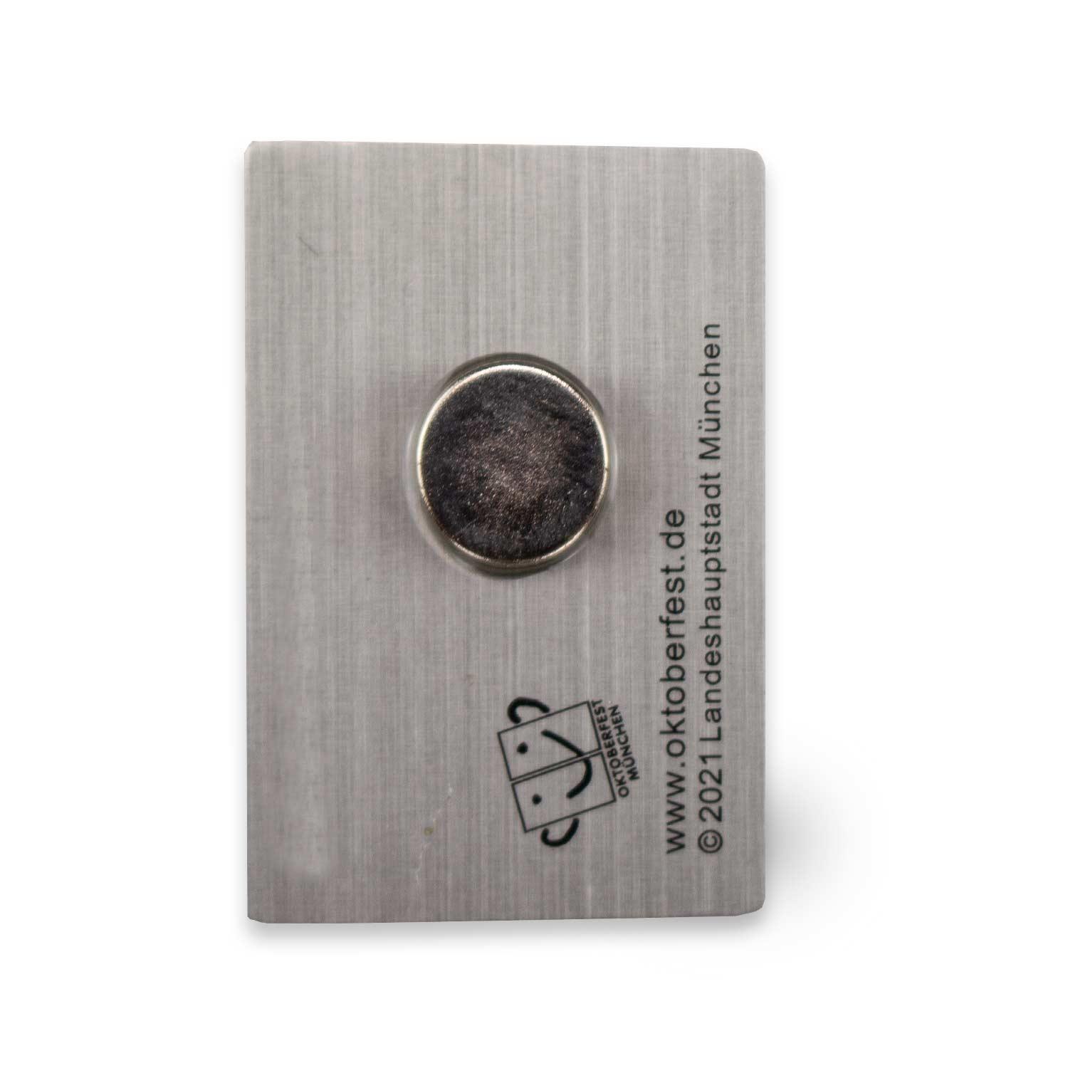 Rechteckiger Magnet mit offiziellem Oktoberfest 2021-Motiv, Herzdesign, Schriftzug „Oktoberfest“, Blau- und Brauntöne; ca. 2,8 × 4 cm.