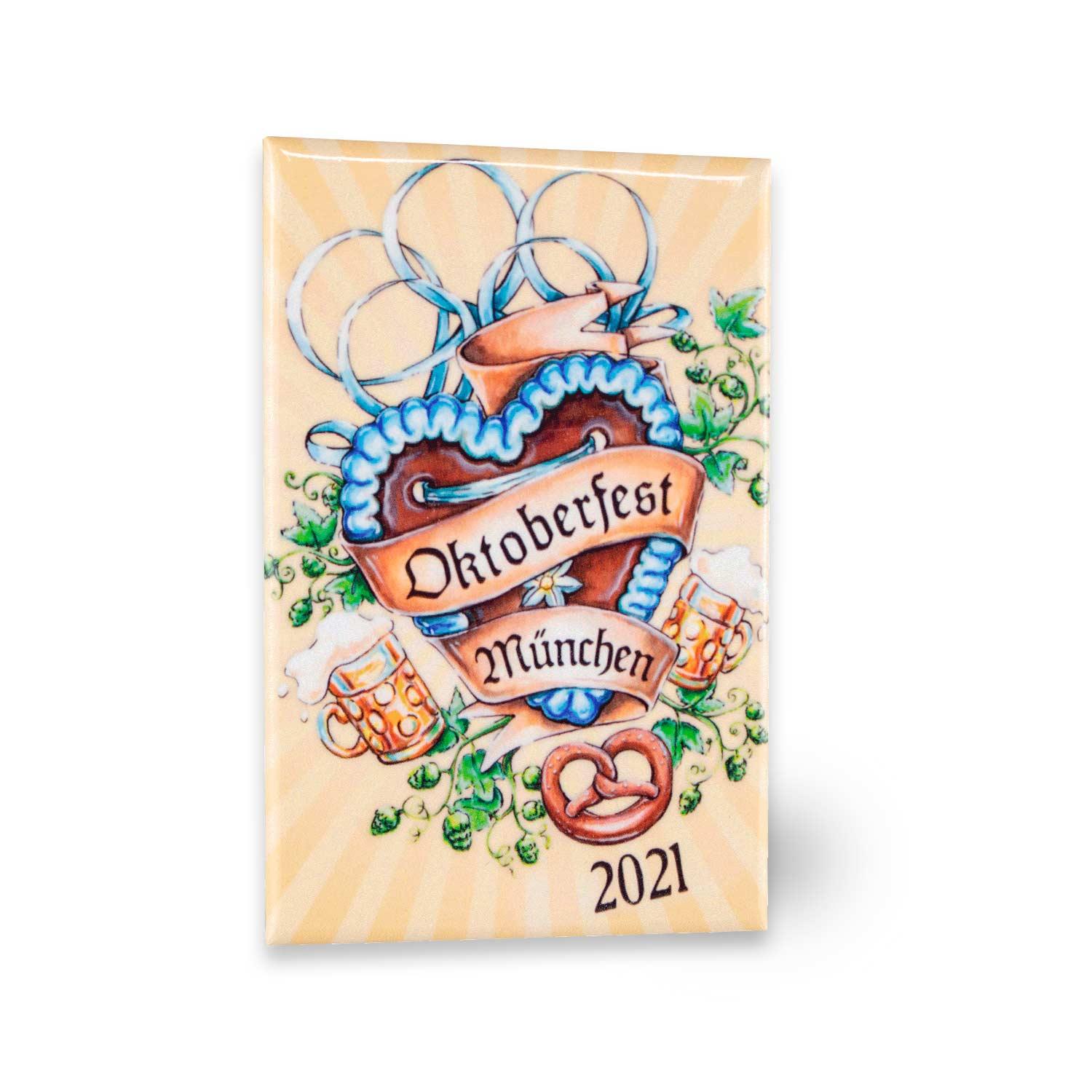 Offizieller Pin Oktoberfest 2021 mit Herzbanner, Bierkrügen, Brezel und Hopfenranken auf gestreiftem Hintergrund.