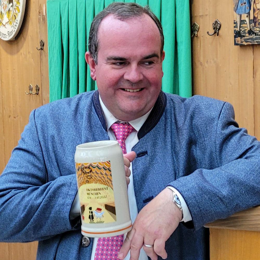 Oktoberfestkrug 2022 aus Steingut mit detailreichem Motiv und Schriftzug, 1,0 l, limitierte Auflage.