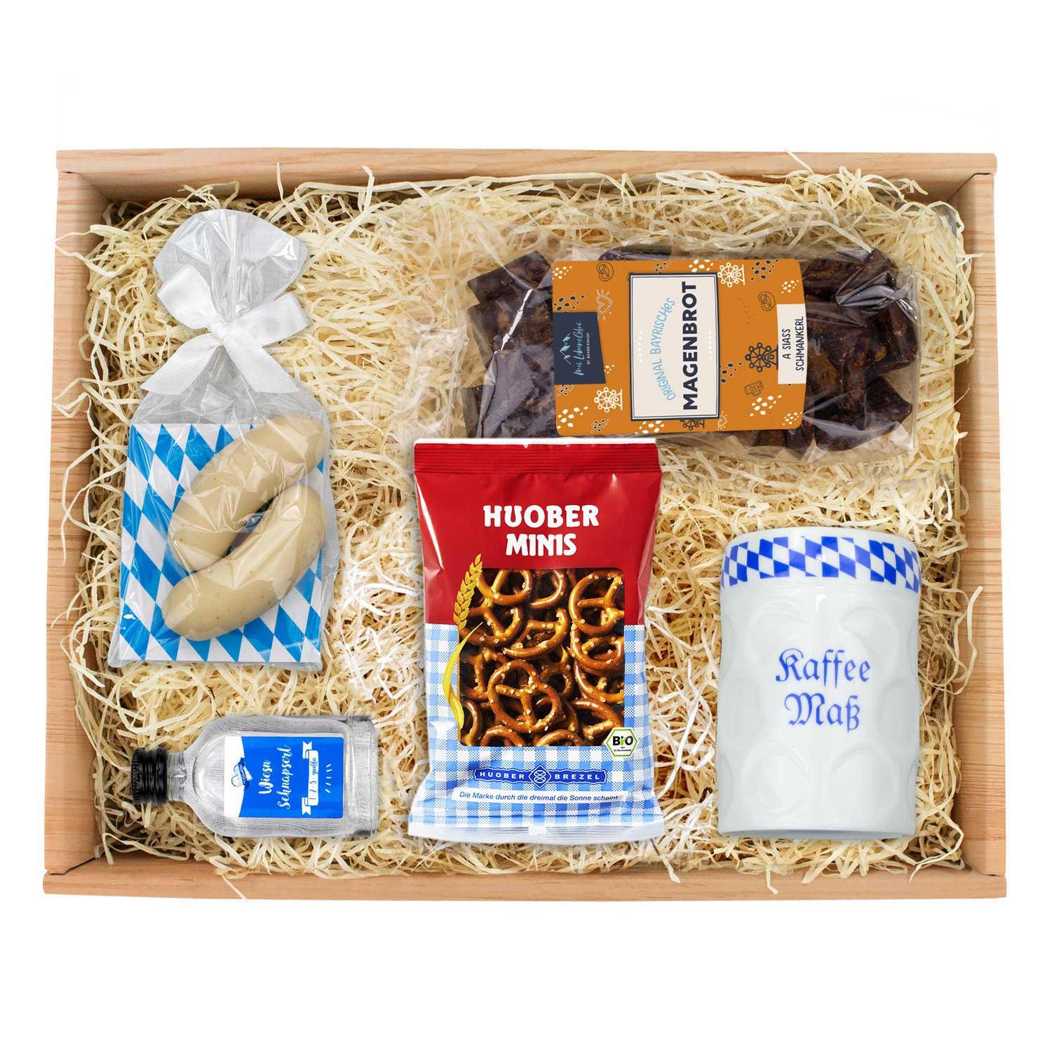 Oktoberfest-Box Maßkrug-Tasse mit Magenbrot, Brezeln, Schnaps und weiterer bayerischer Feinkost in Holzkiste.
