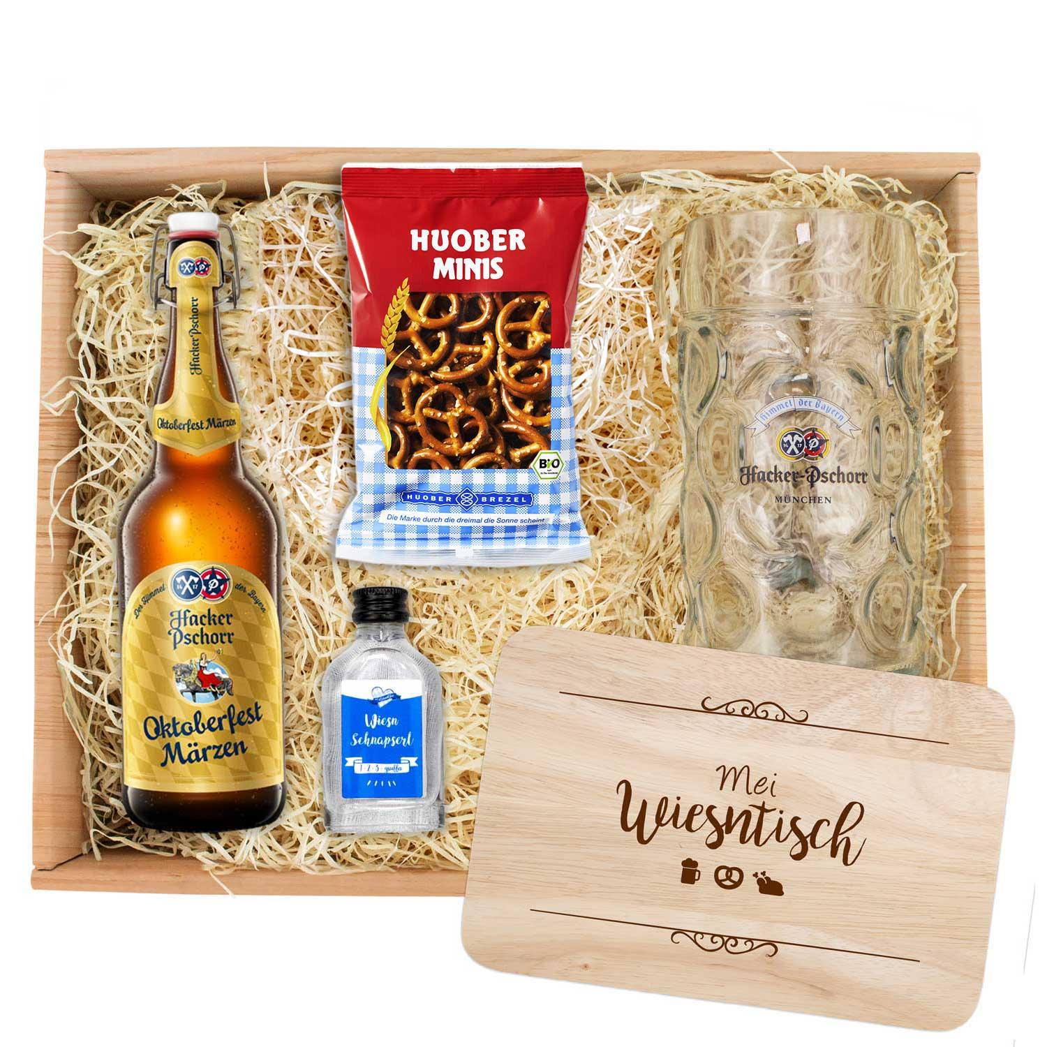 Oktoberfest-Set mit zwei Bierflaschen, Maßkrug aus Glas und graviertem Holzbrett in Herzform mit Rautenmuster.