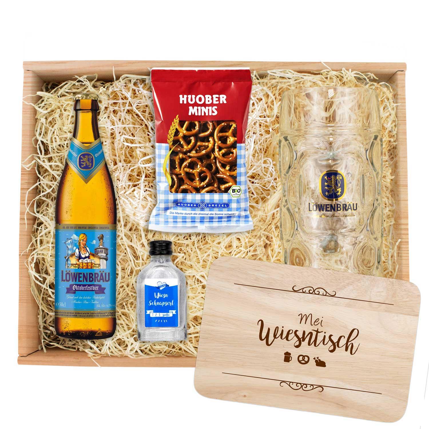 Oktoberfest-Box mit zwei Löwenbräu-Oktoberfestbieren, Maßkrug, Holz-Brotzeitbrett und Serviette im Rautenmuster.