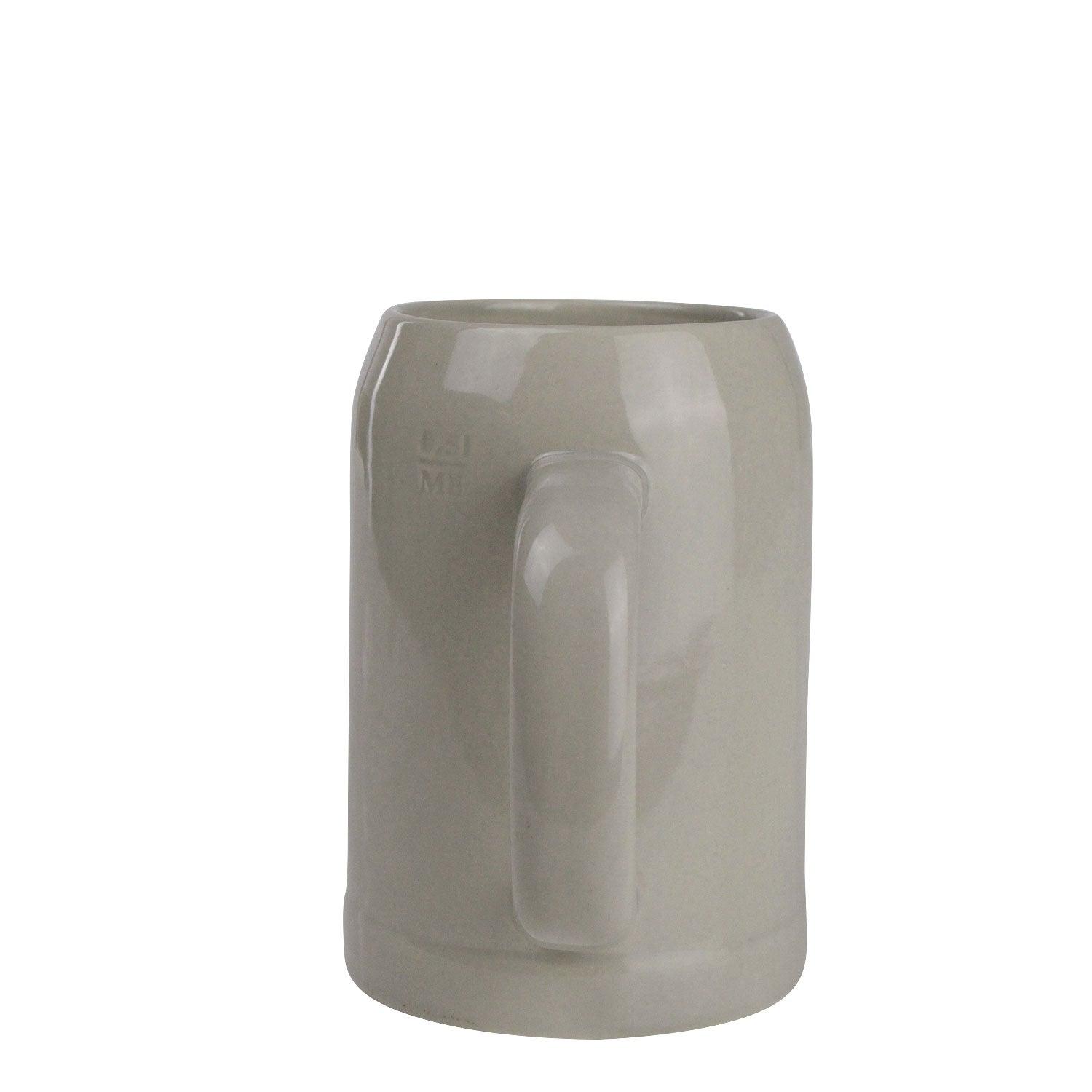 Hellgrauer Bierkrug aus Steingut mit blauem Schriftzug, geschwungener Form und Henkel, Füllmenge 0,5 l, Höhe ca. 14 cm.