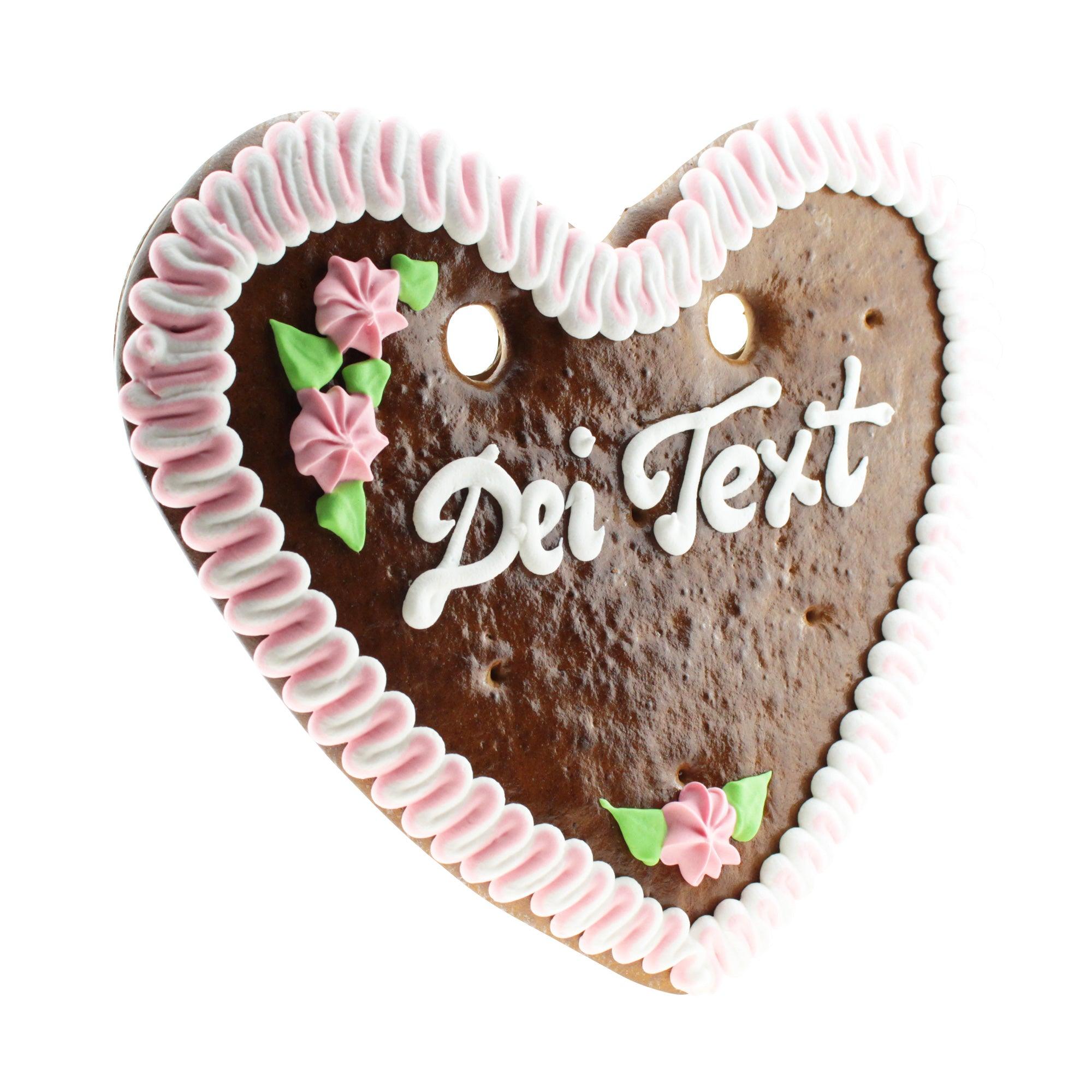 Herzförmiges Lebkuchenherz mit weiß-blauer Zuckerdekoration und rotem Rand, personalisierbarer Schriftzug, ca. 32 × 28 cm, 180 g.