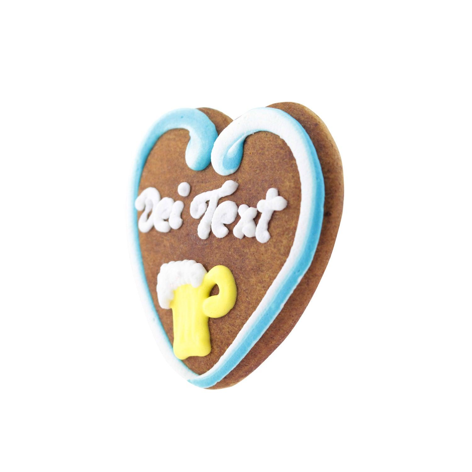 Braunes Lebkuchenherz mit rosafarbener Zuckerschrift, weißer Umrandung und kleinen rosa Zierblumen, handgefertigt aus Teig, ca. 10 × 10 cm.