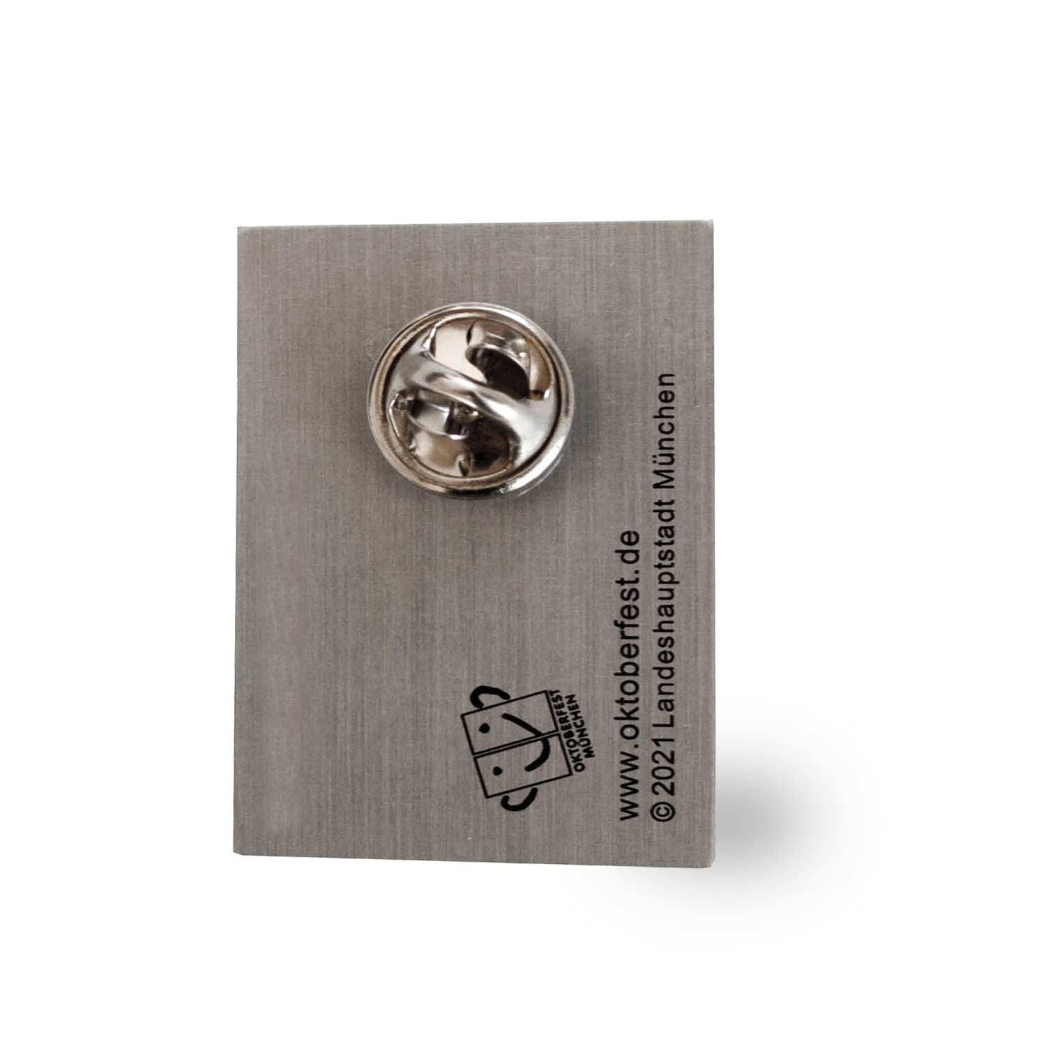 Pin mit offiziell lizenziertem Oktoberfest 2021-Motiv in Lebkuchenherzform, rot-blau, ca. 2,8 × 4 cm.