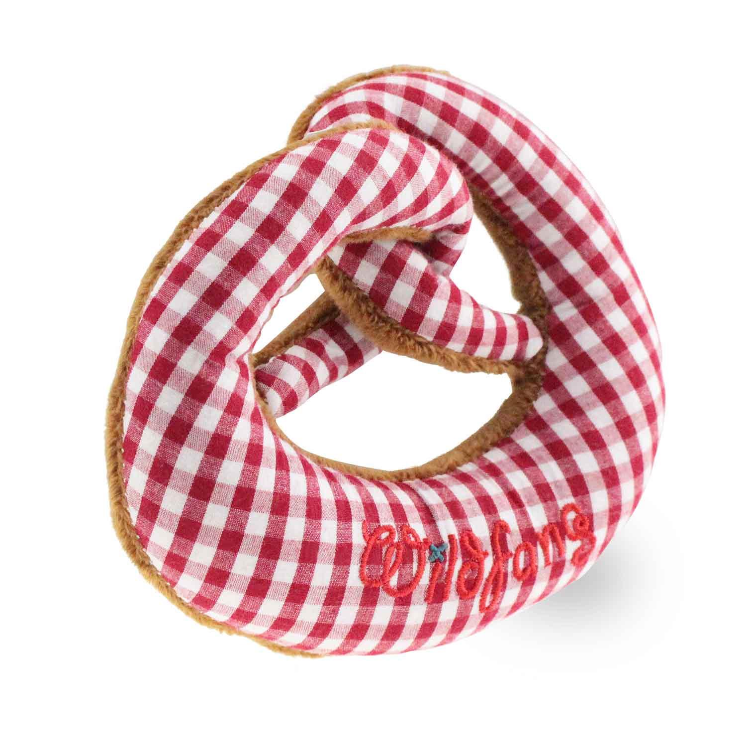 Weiche Plüsch-Breze in Rot mit gesticktem Schriftzug und integrierter Rassel, waschbar, ca. 15 x 13 cm.