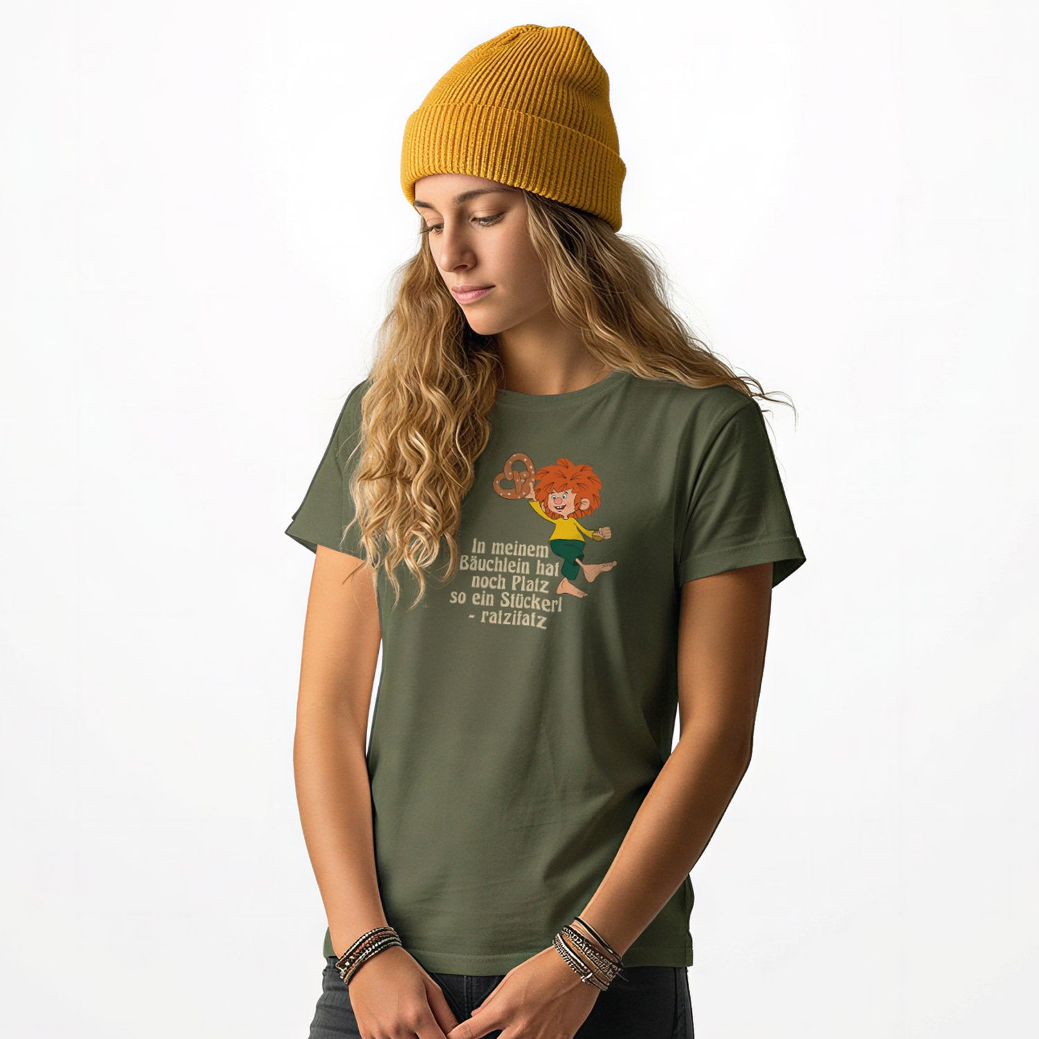 Junge Frau trägt olivgrünes Pumuckl Damen T-Shirt mit Aufdruck und gelber Beanie-Mütze