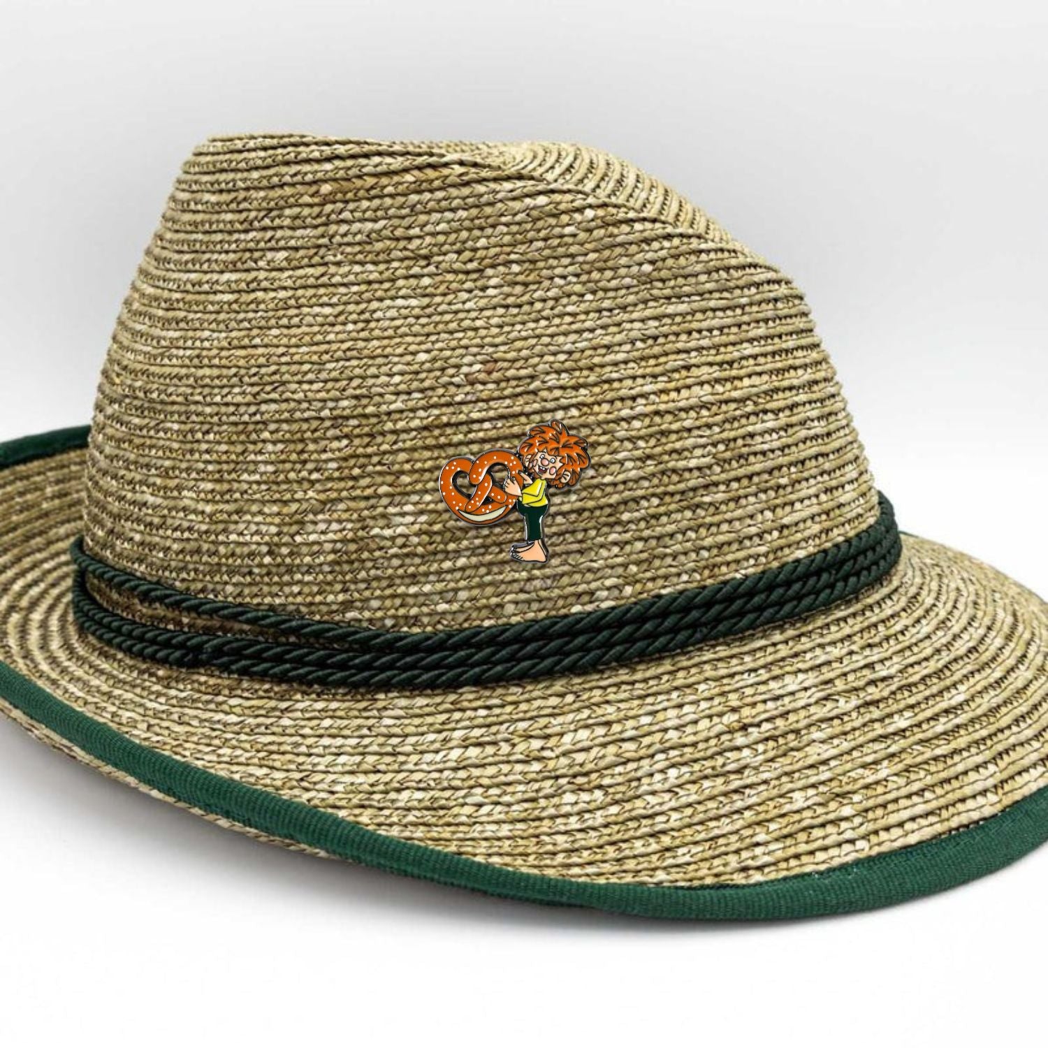 Pumuckl Pin mit Brezel an einem traditionellen strohgeflochtenen Trachtenhut mit grünem Band