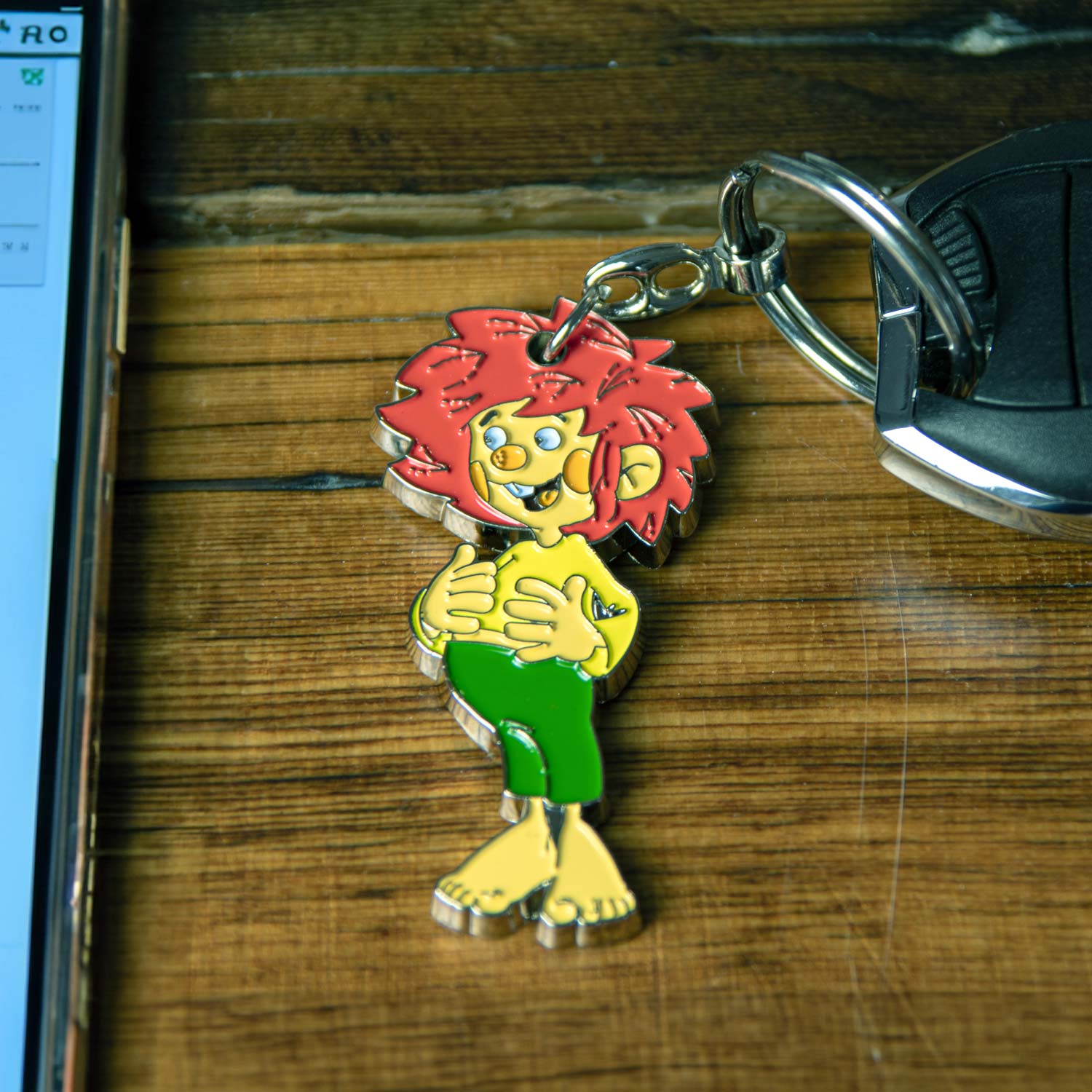 Emaillierter Schlüsselanhänger als Pumuckl-Figur mit Schlüsselring, farbenfroh, ca. 11 cm groß.