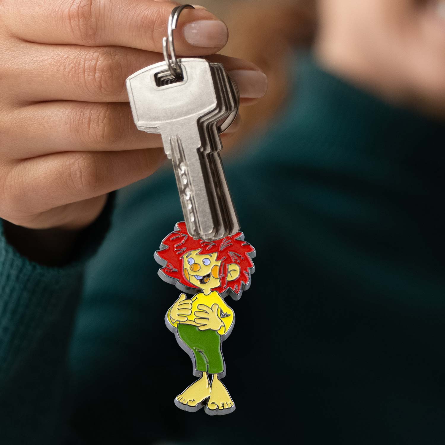 Emaillierter Schlüsselanhänger in Form einer Comicfigur mit roten Haaren, stabilem Ring, ca. 11 cm groß.