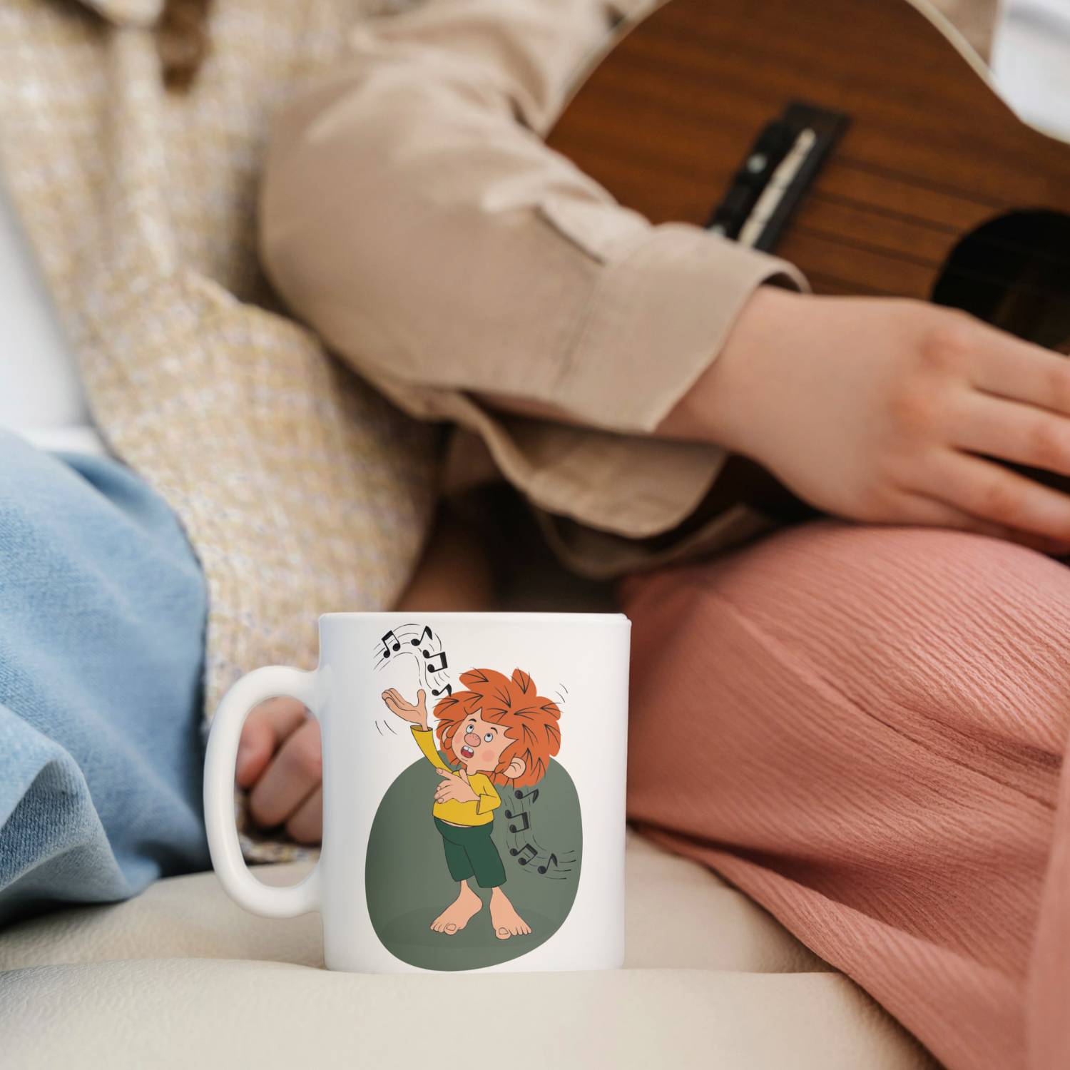 Weiße Pumuckl Tasse Musik mit freudigem Kobold und Noten, daneben eine Person mit Ukulele.