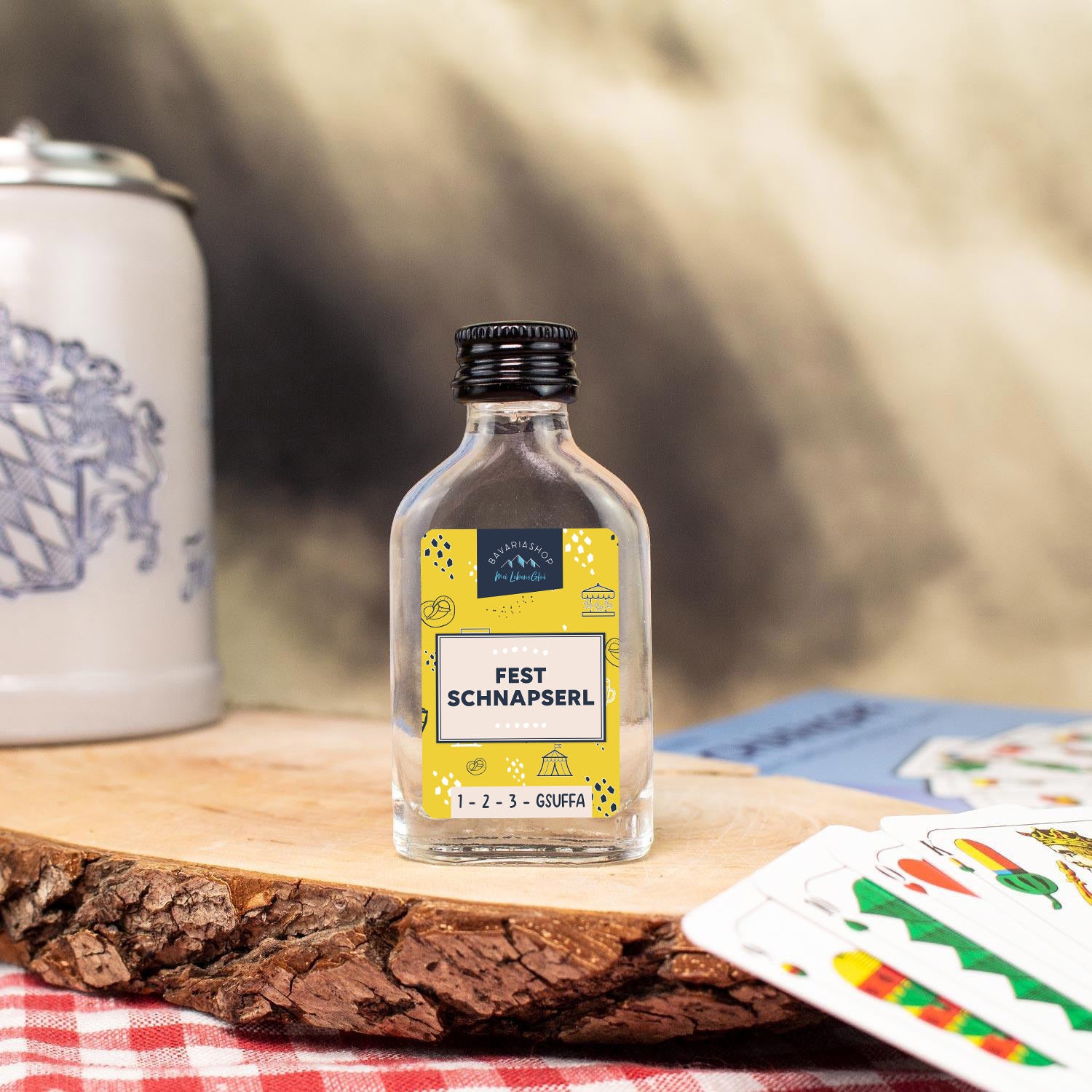 Klarer Obstler in kleiner Glasflasche mit 2 cl Inhalt, weißem Etikett und blauem Schriftzug „Fest Schnapserl“, 38 % vol.