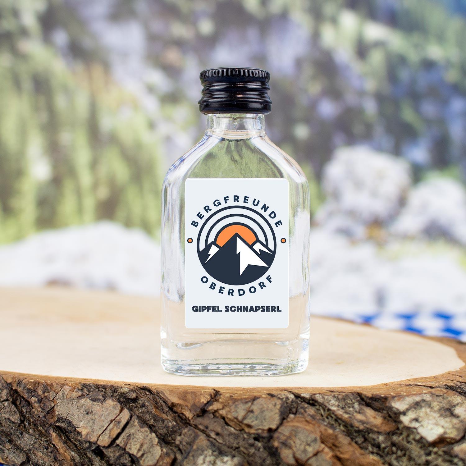 Transparente Mini-Schnapsflasche mit Obstler und individuellem Logoaufdruck, zylindrisch, 20 ml, ab 144 Stück.