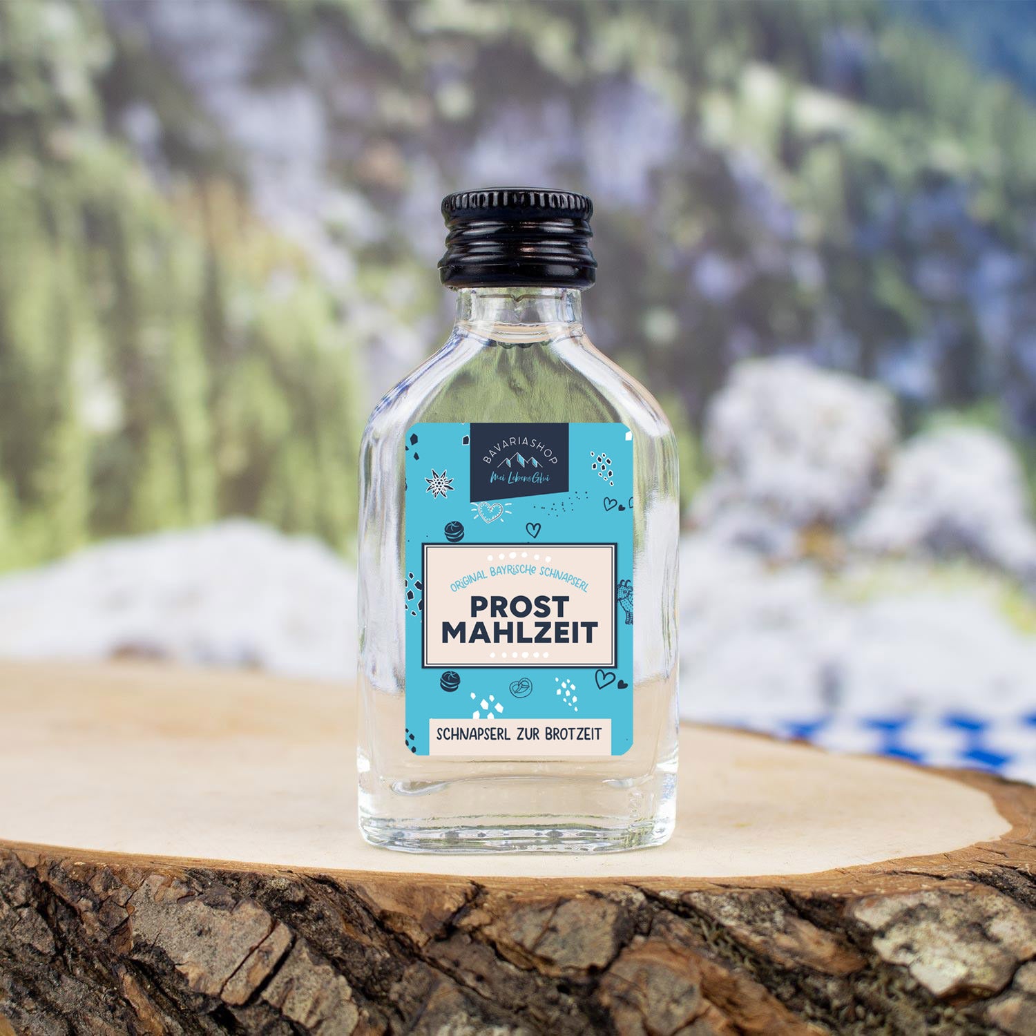 Kleiner Obstler mit 38 % vol. in transparenter 2-cl-Flasche, Motiv „Prost Mahlzeit!“ auf der Vorderseite.