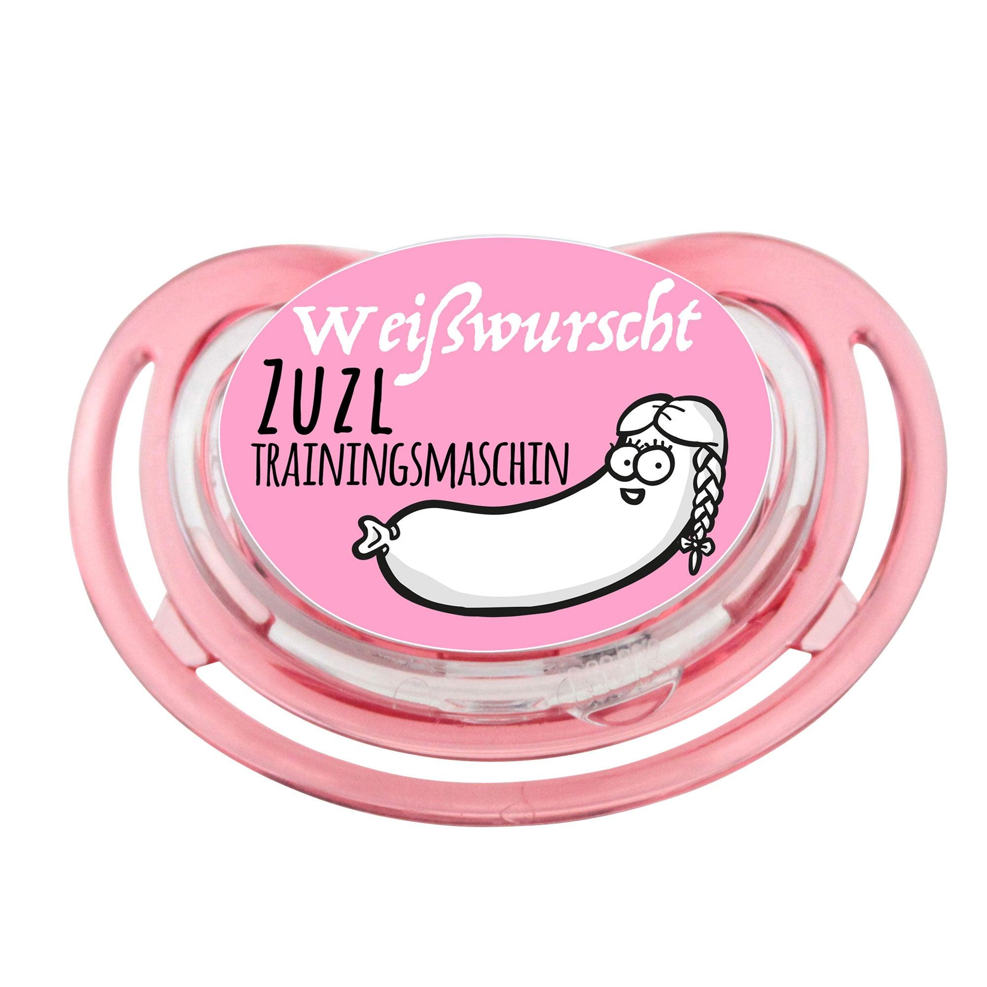 Weißer Schnuller mit bayrischem "Weißwurscht-Zuzltrainingsmaschin"-Schriftzug, rundem Silikon-Sauger und rosa Details.