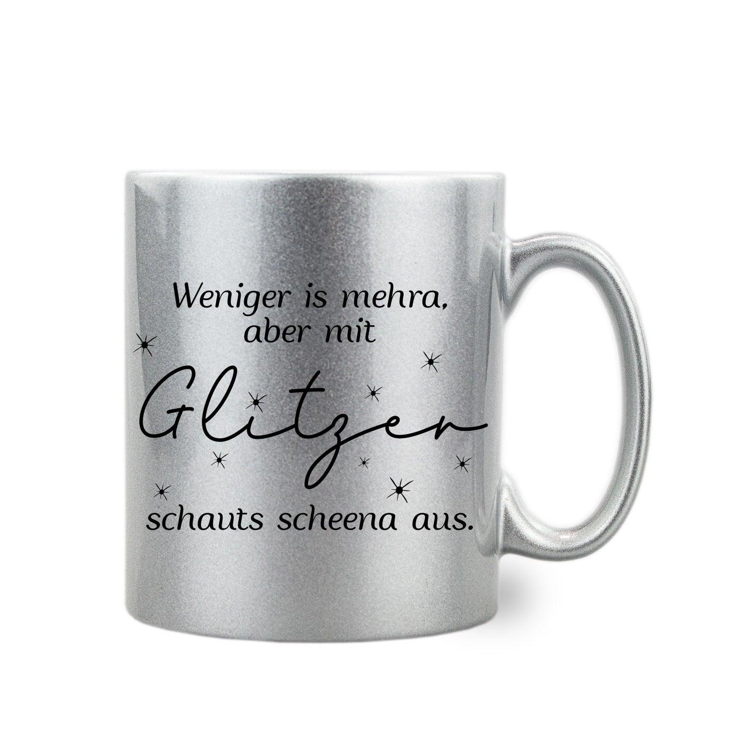 Silberner Glitzer-Haferl mit schwarzem Schriftzug „Weniger is mehra, aber mit Glitzer schauts scheena aus“, 300 ml.