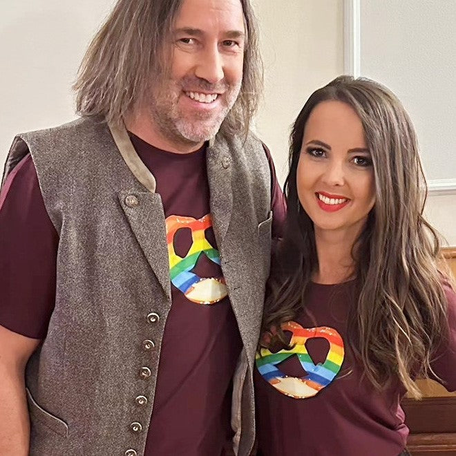 Weinrotes Damen-T-Shirt mit Regenbogen-Brezn-Motiv und Aufdruck „Weiß-blaues Zeichen für ein buntes Bayern“.