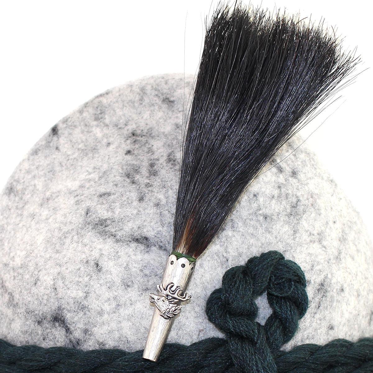 Traditioneller Gamsbart in fächerförmiger Anordnung mit dunklem Naturhaar und verzierter Metallhülse, ca. 13 cm hoch.